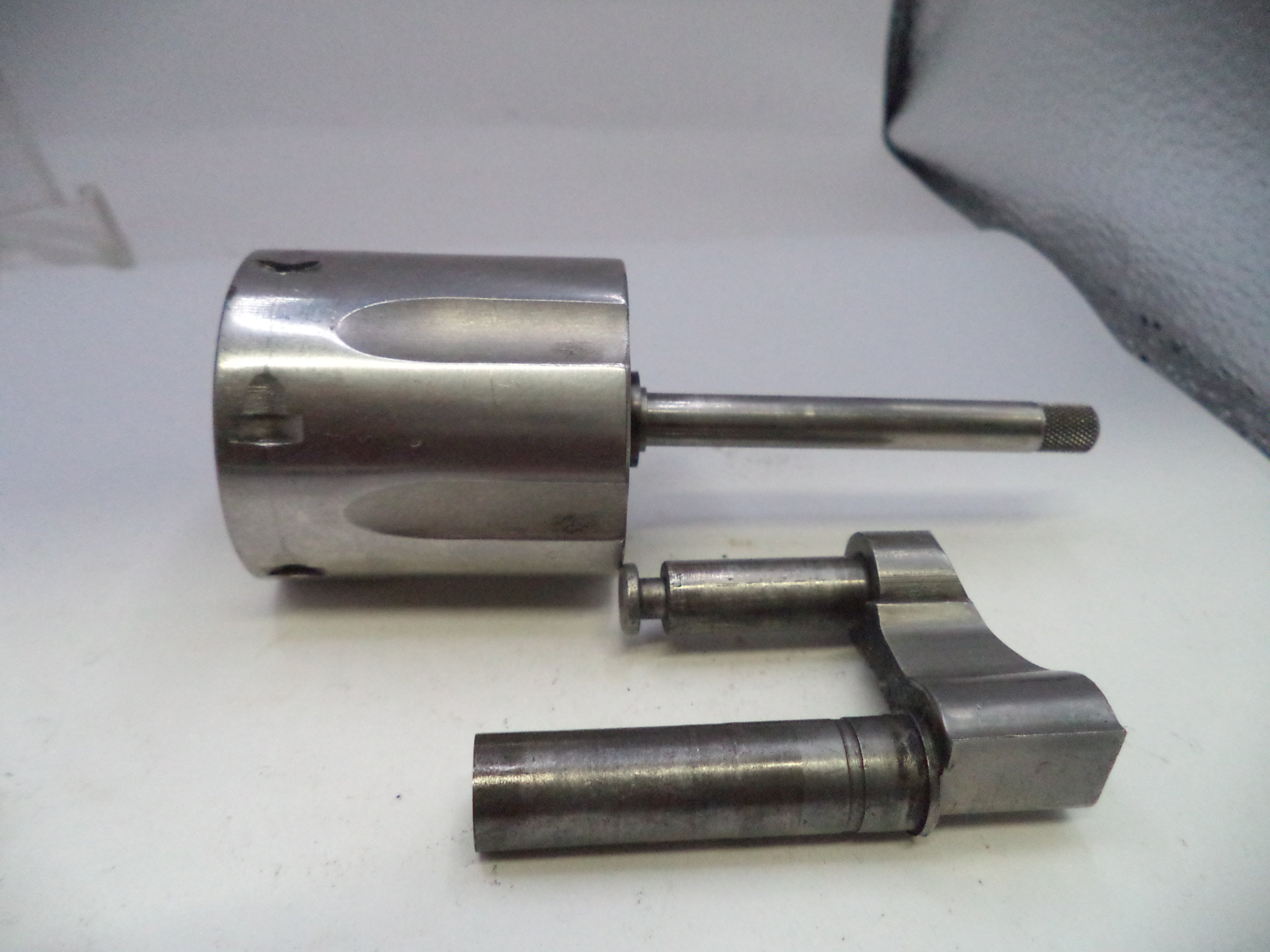 Two metal cylindrical components on a white surface