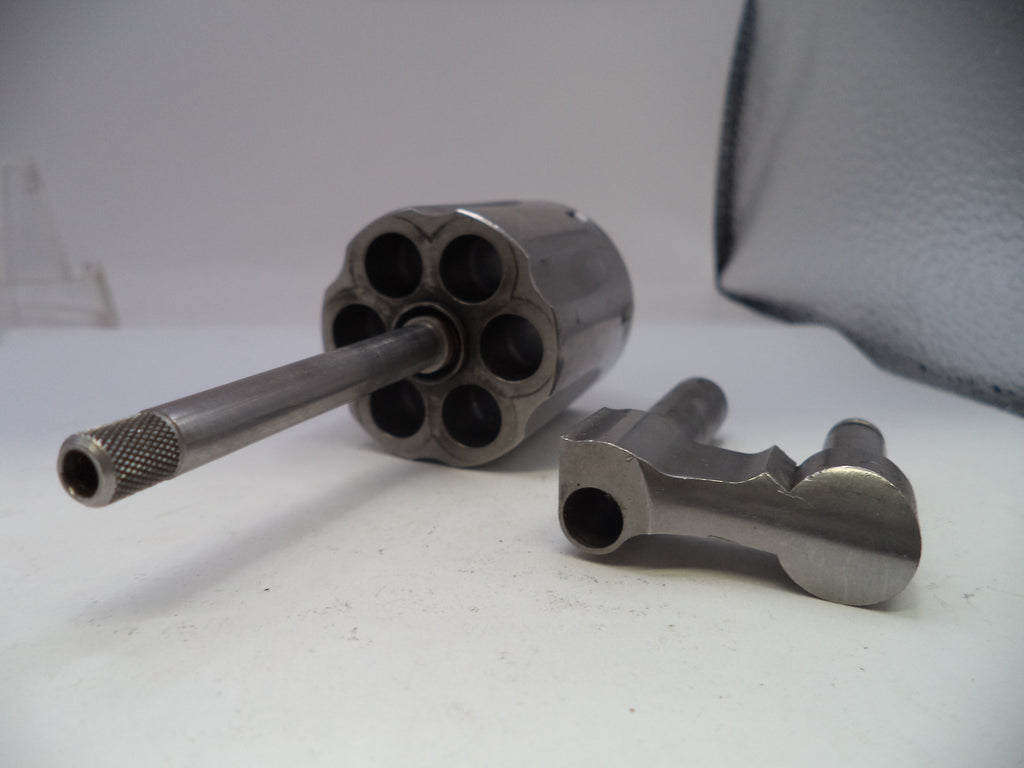 Metallic revolver barrel and cylinder on a white surface