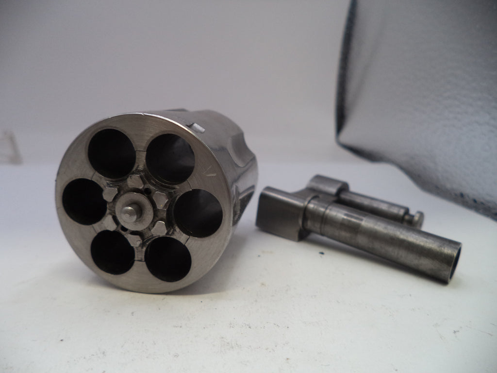 Metallic revolver barrel and cylinder on a white surface