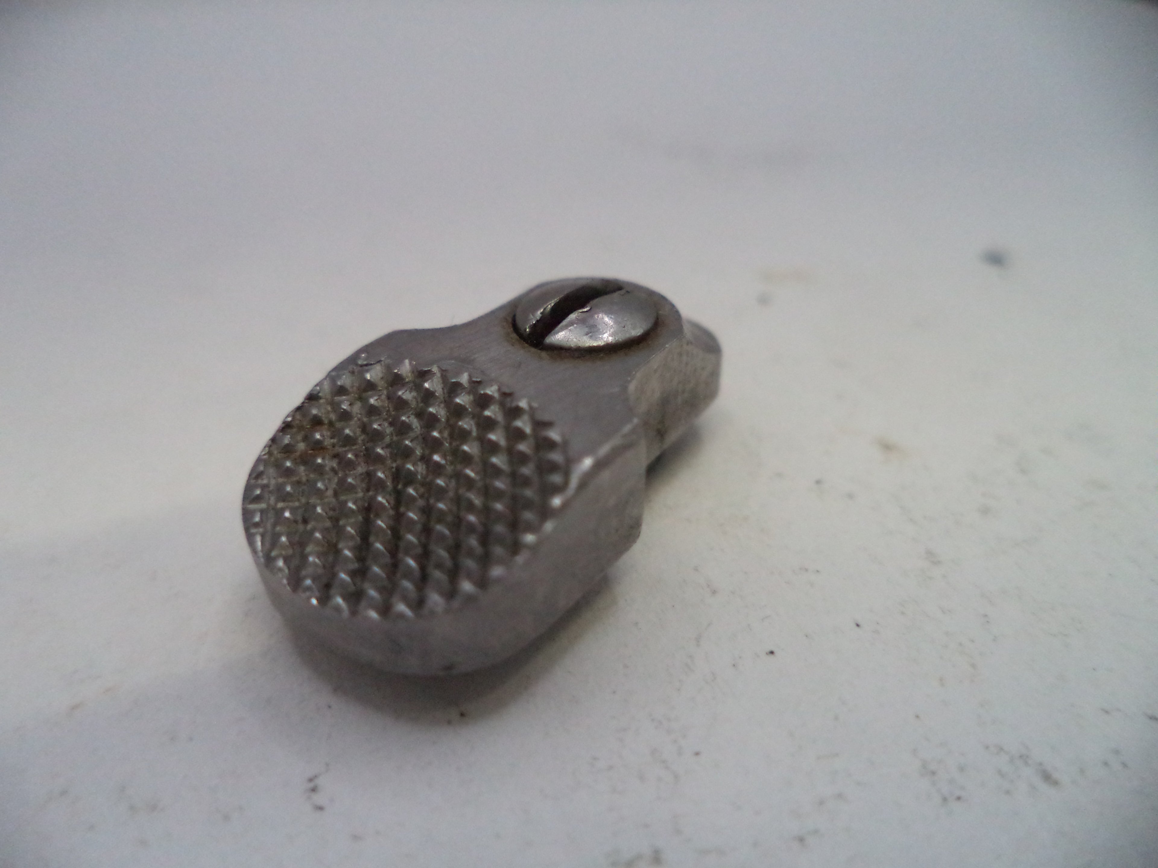Metal tool with textured surface on a light gray background