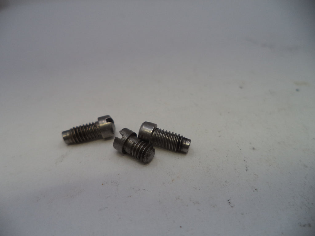 Three metal screws on a white surface