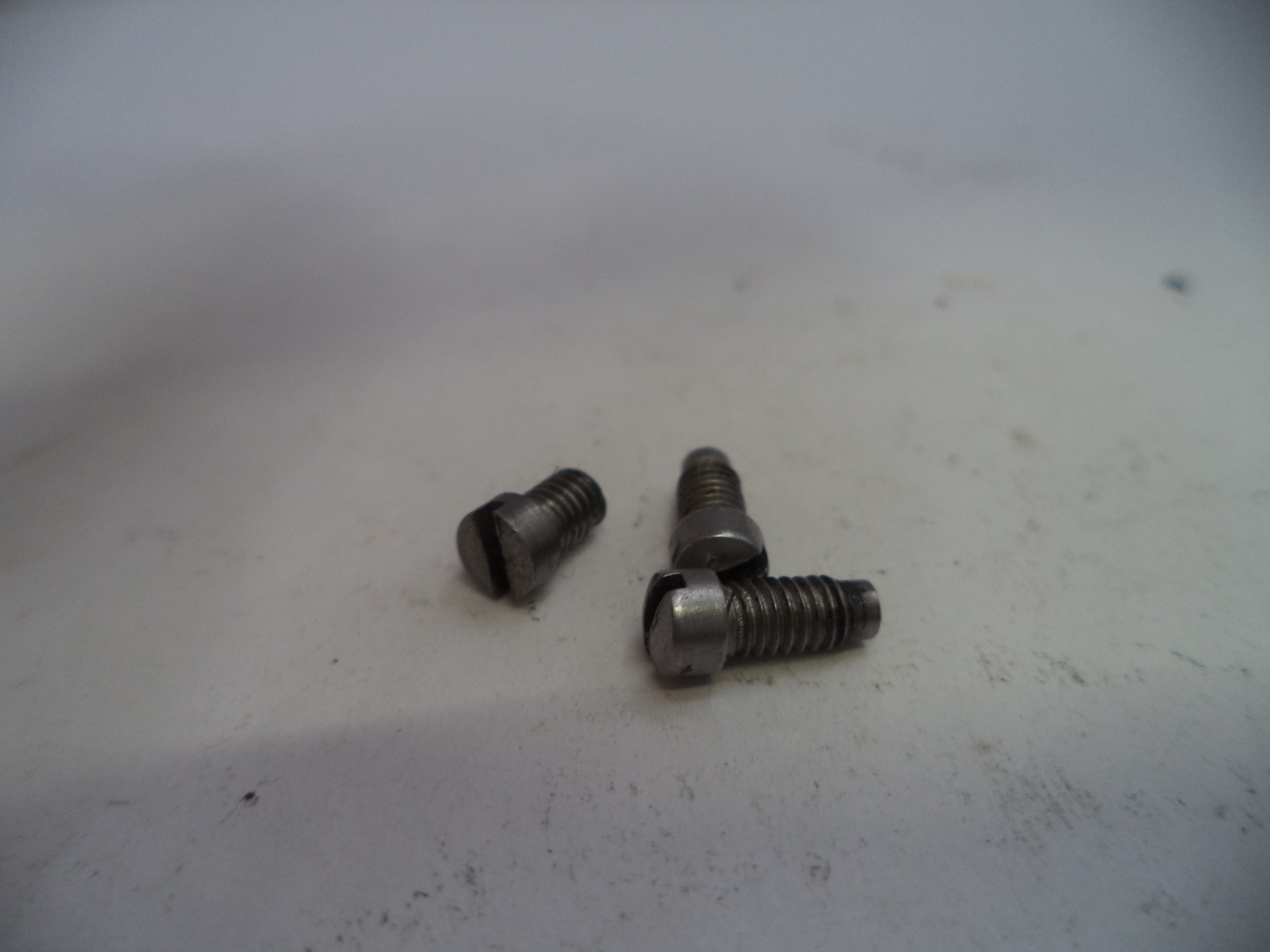 Three metal screws on a white surface
