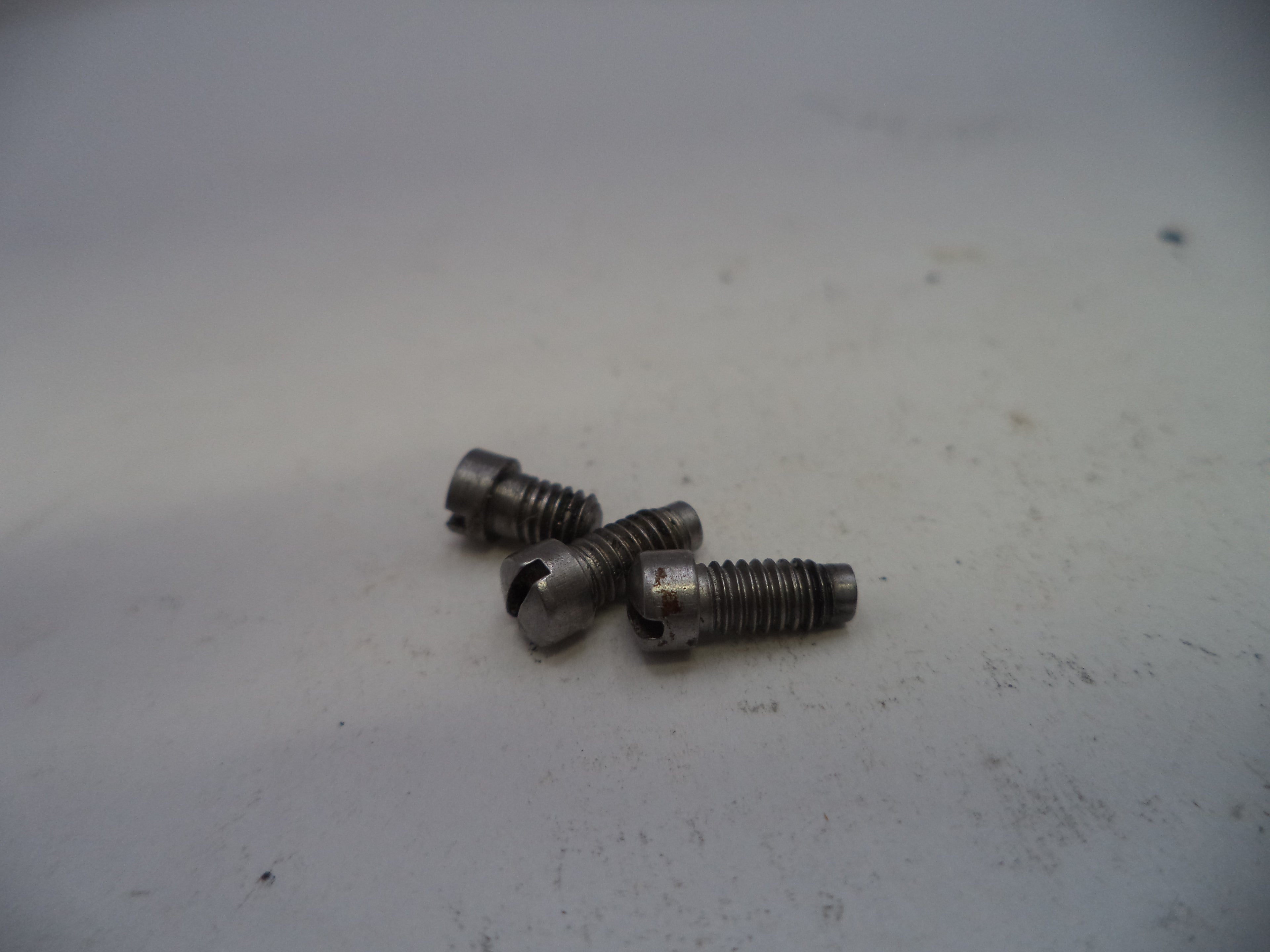 Three metal screws on a white surface