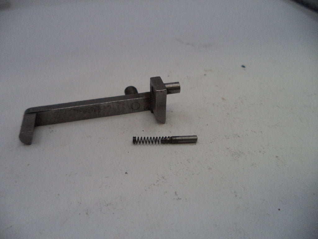 Metal tool and spring on a white surface