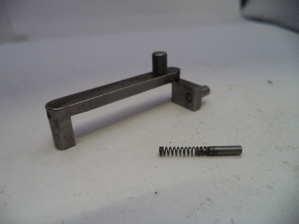 Metal tool and spring on a white surface