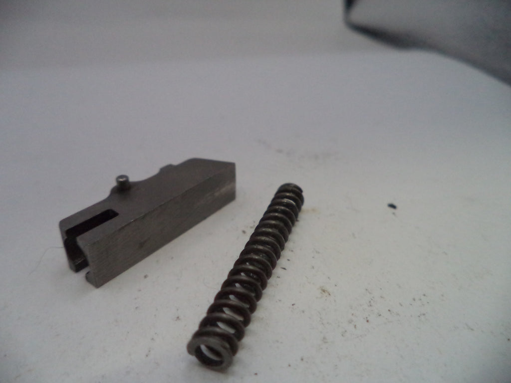 Metal component and spring on a white surface