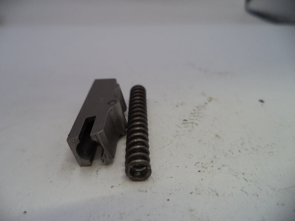 Metal component and spring on a white surface