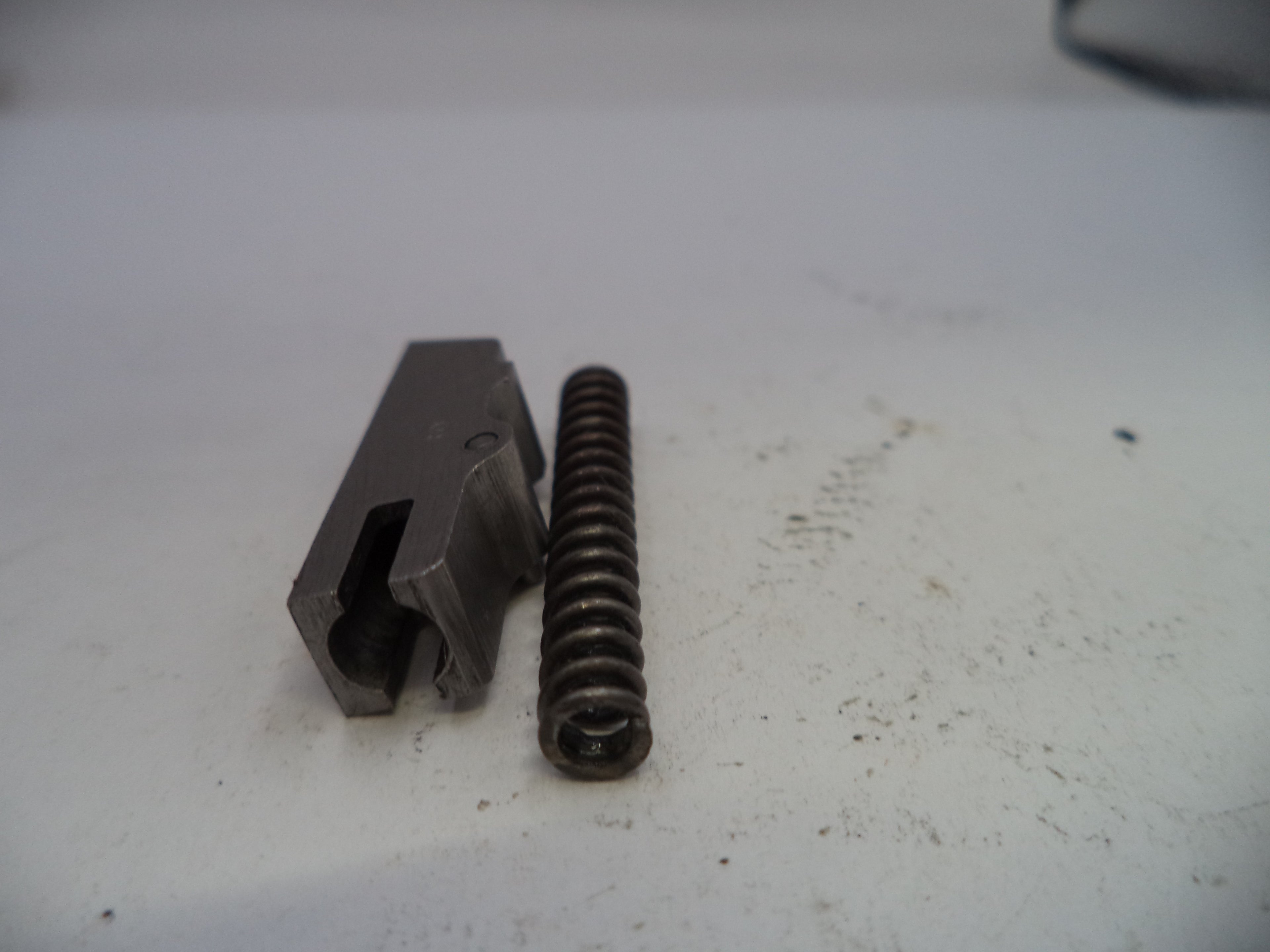 Metal component and spring on a white surface
