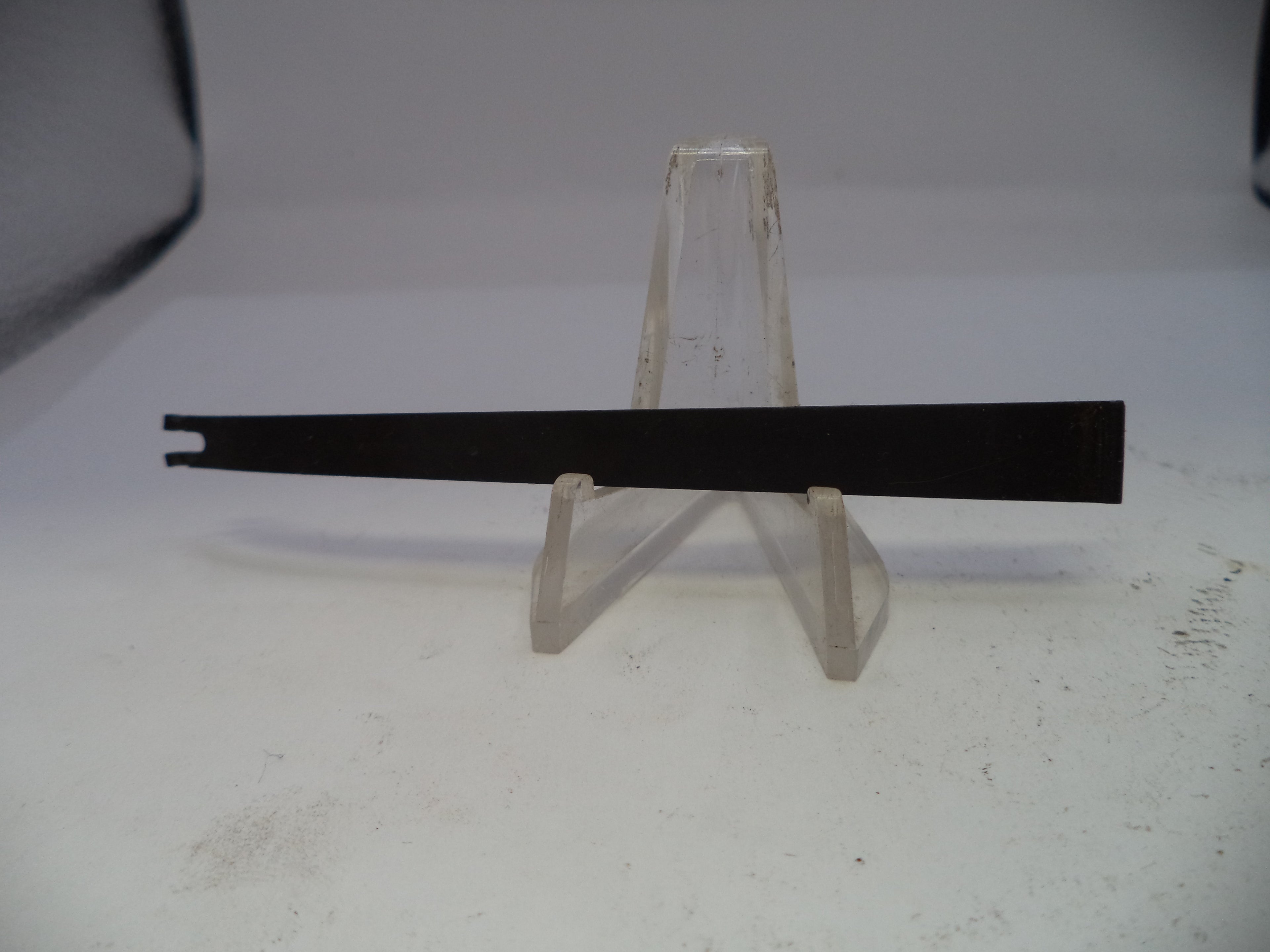 Black metal bar on a clear plastic stand against a white background