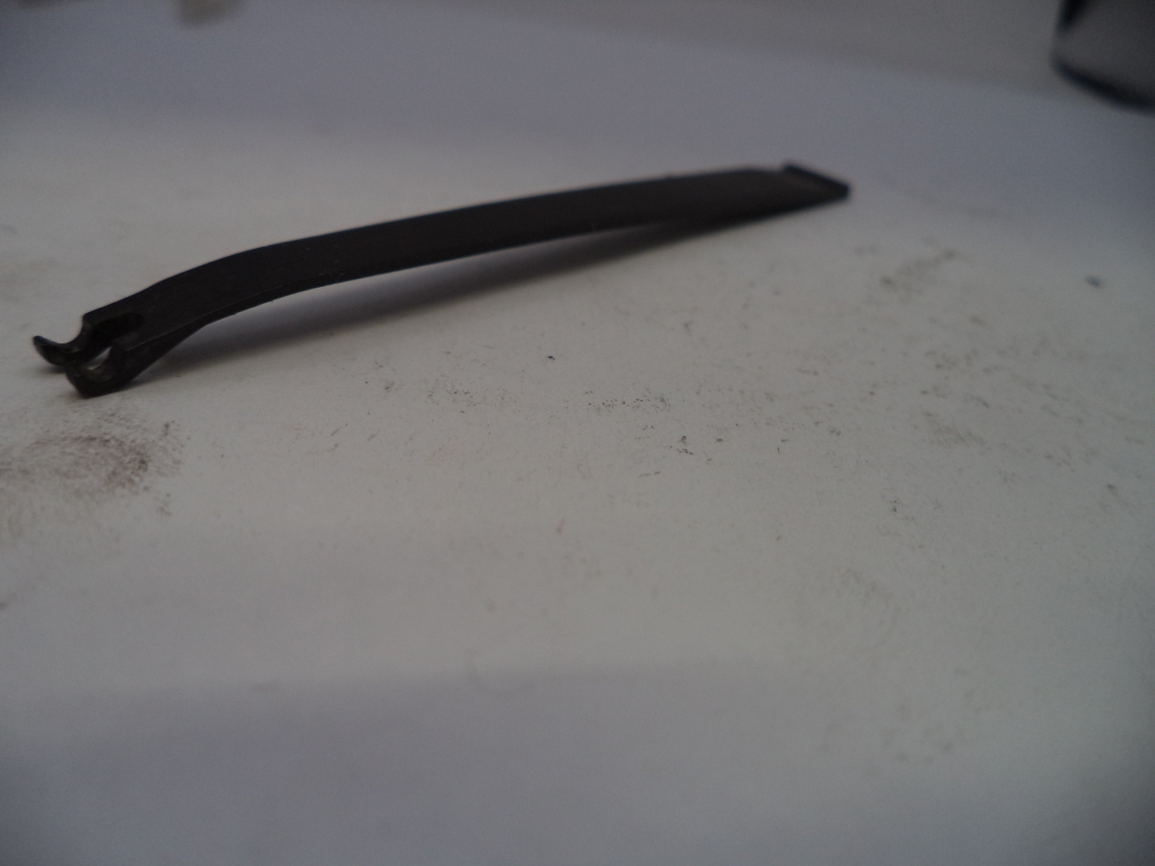 Black rubber band on a white surface with visible dirt