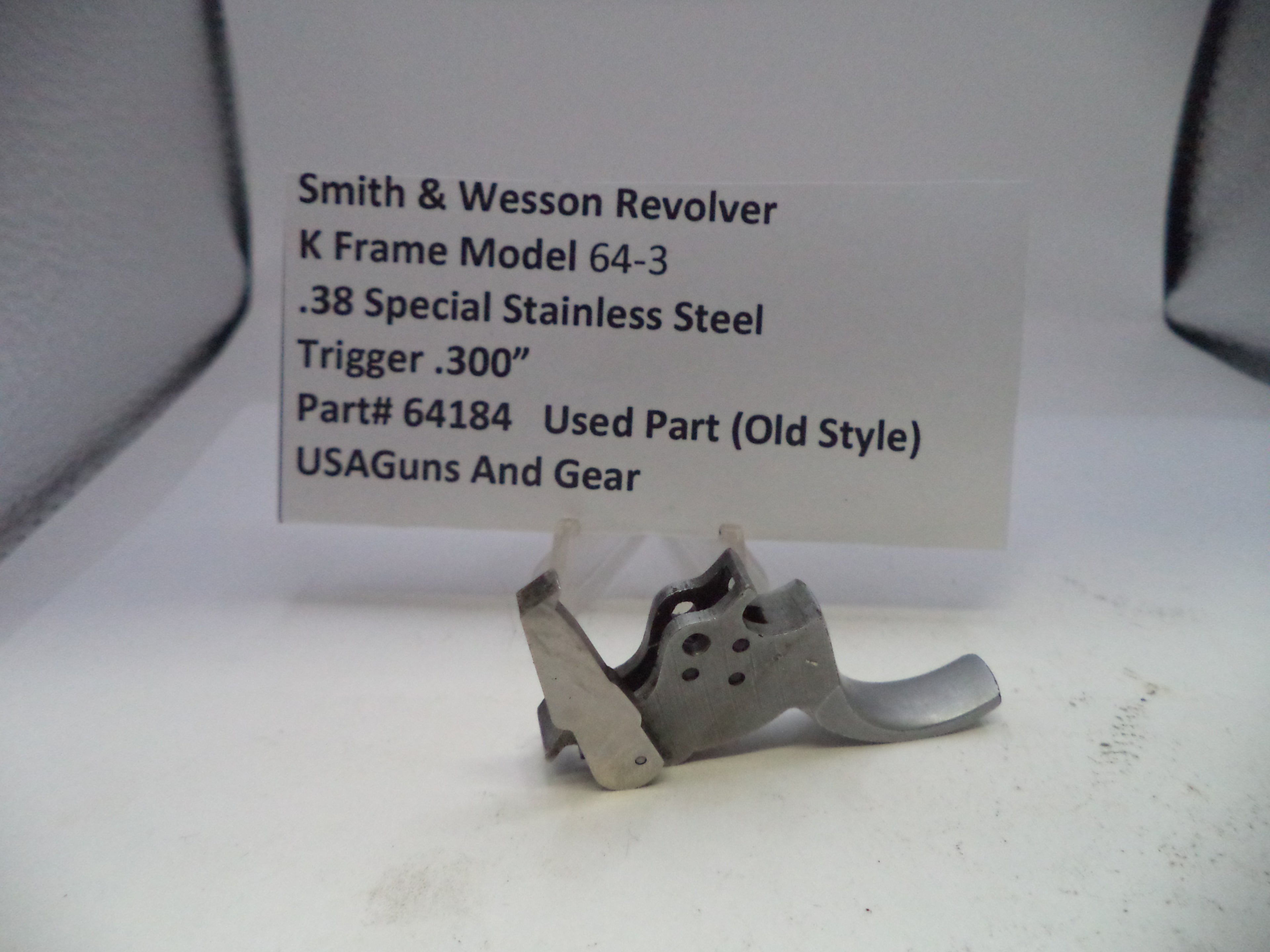 Smith & Wesson revolver trigger part with descriptive label on a white background