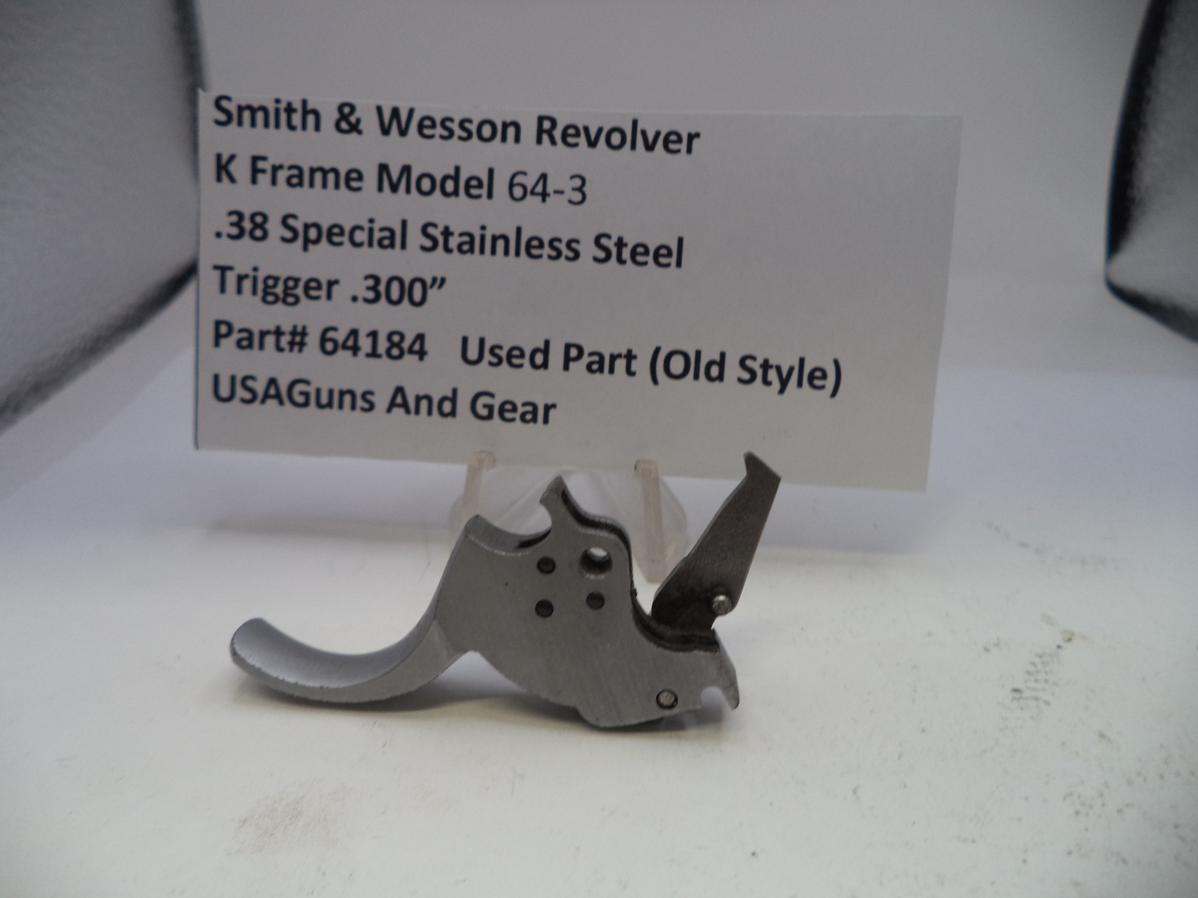 Smith & Wesson revolver trigger part with descriptive label on a white background