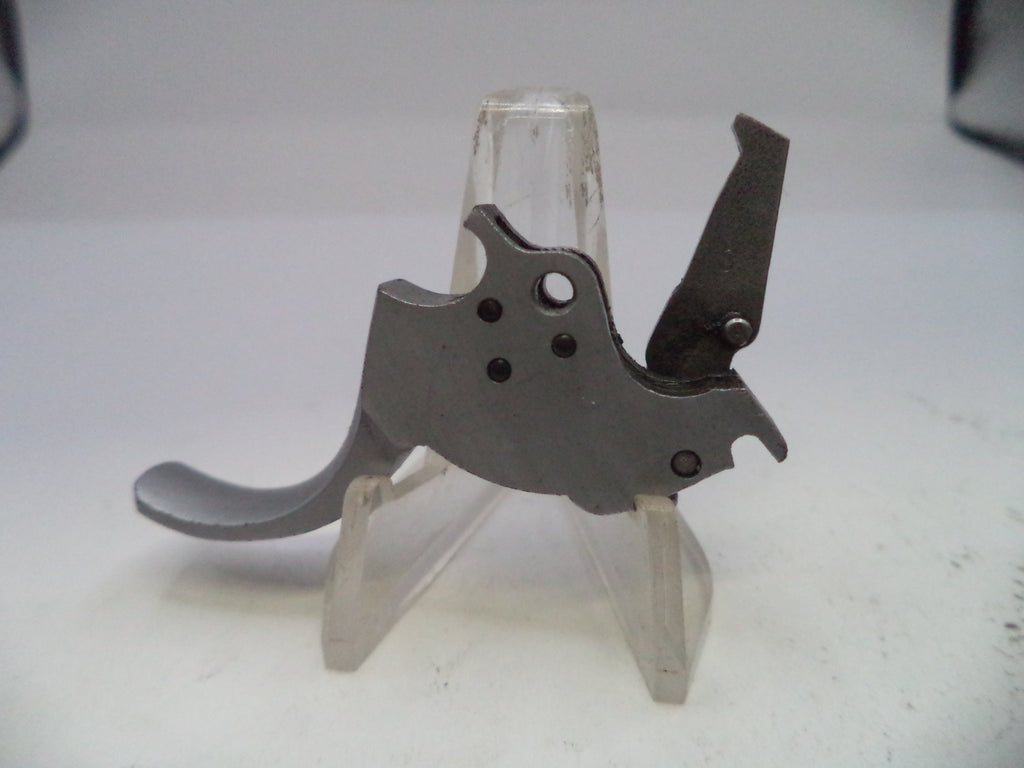 Metallic firearm trigger on a stand with a white background