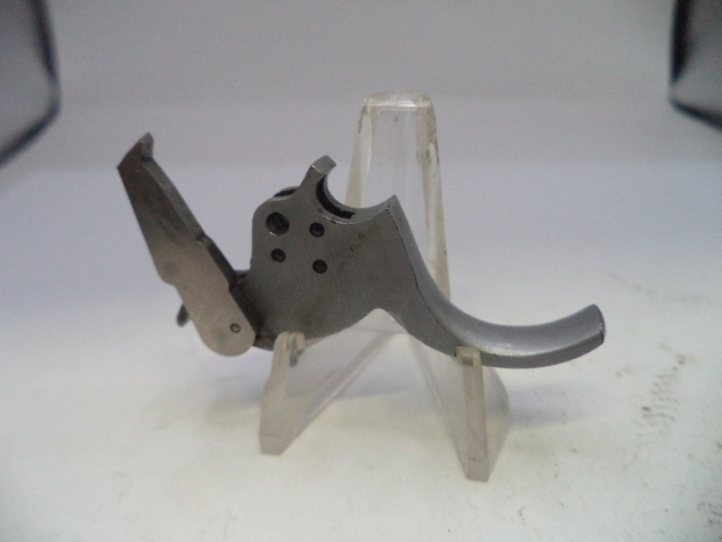 Metallic gun trigger on a stand against a white background