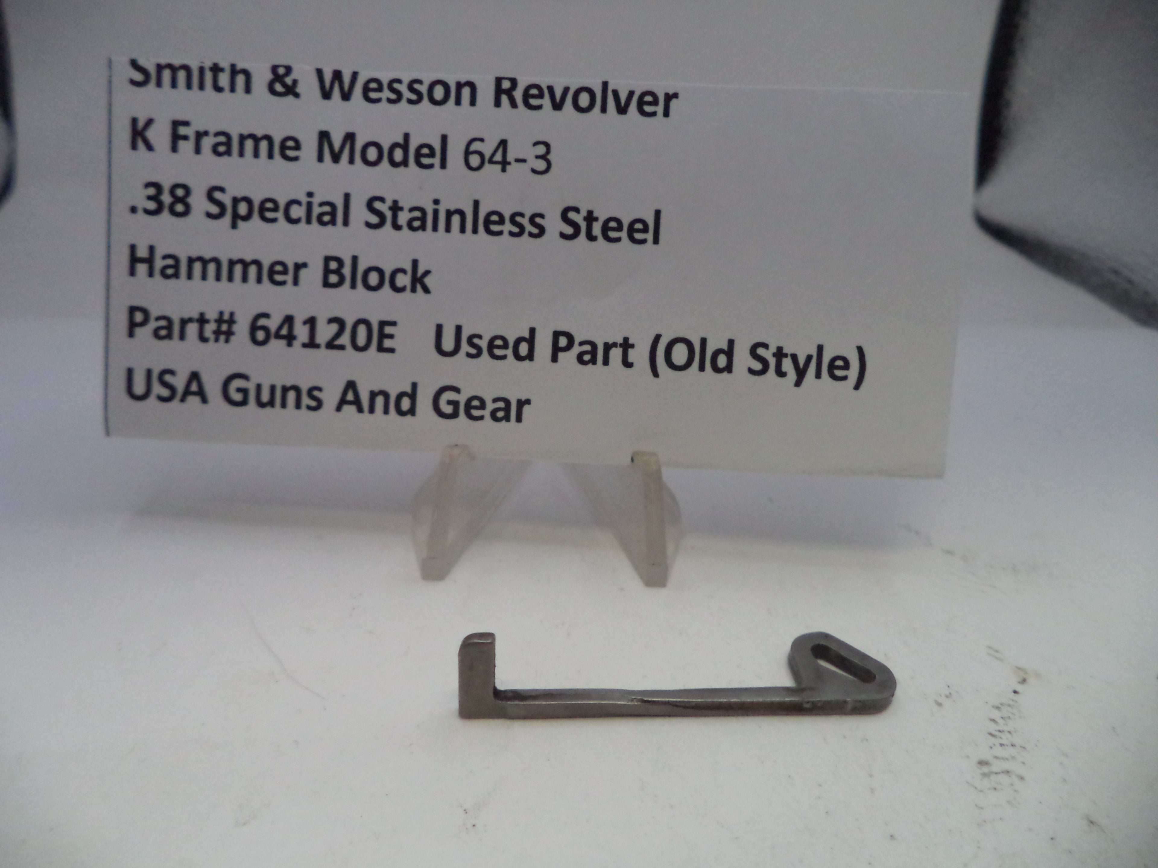 Smith & Wesson revolver hammer block on a white surface with a label in the background.