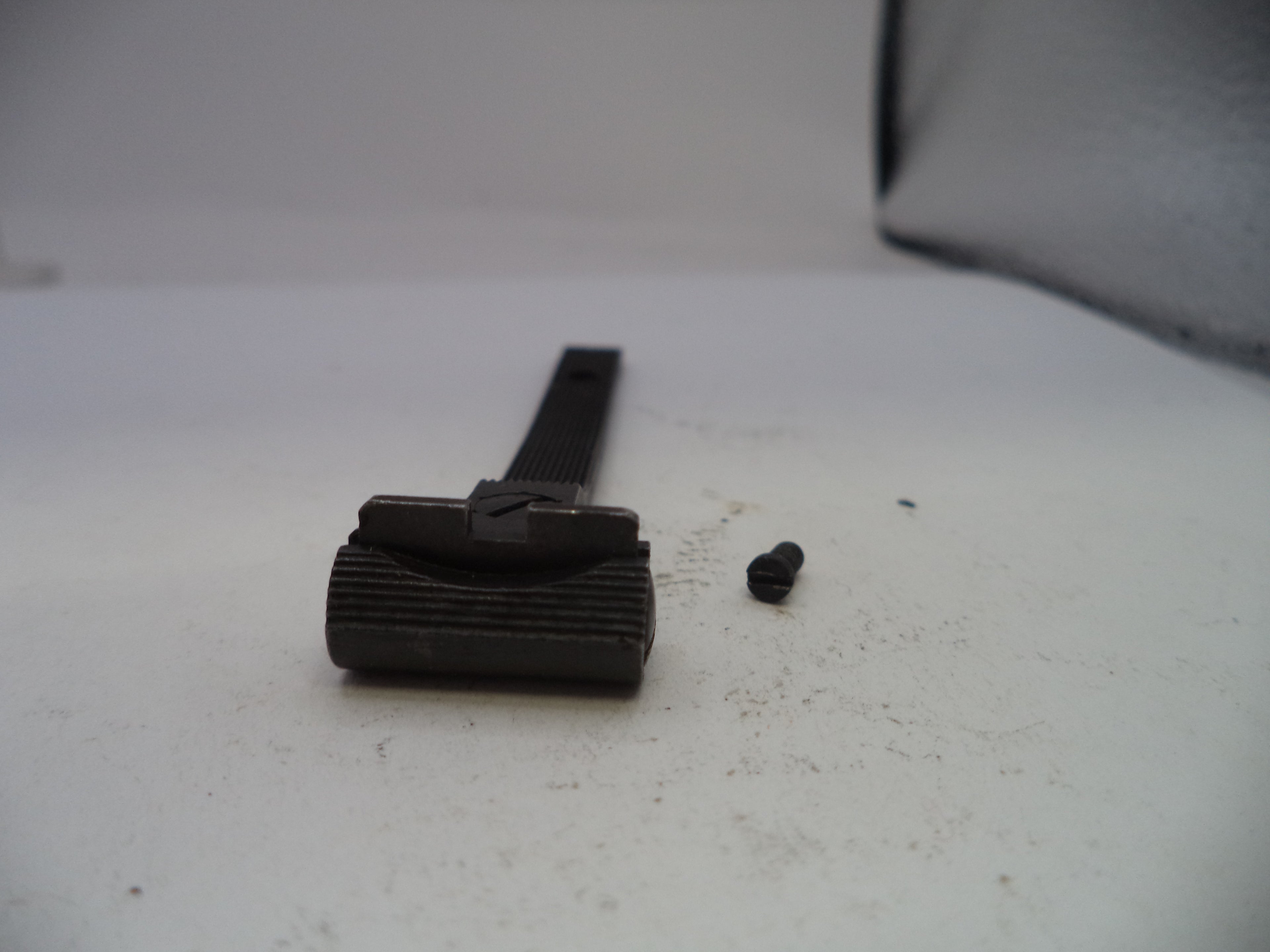 Black metal component on a white surface with a blurred background