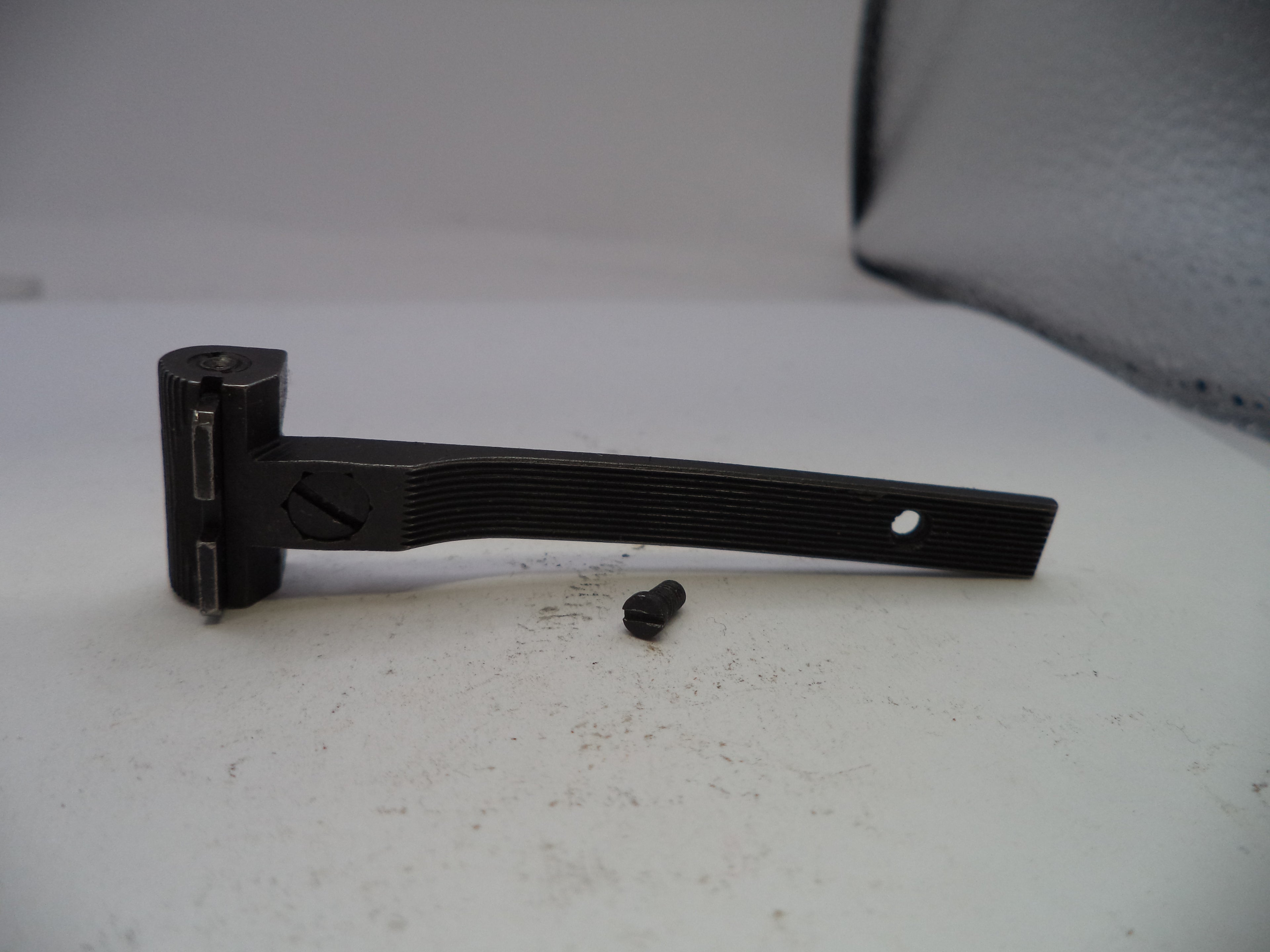 Black metal bracket on a white surface with a blurred background