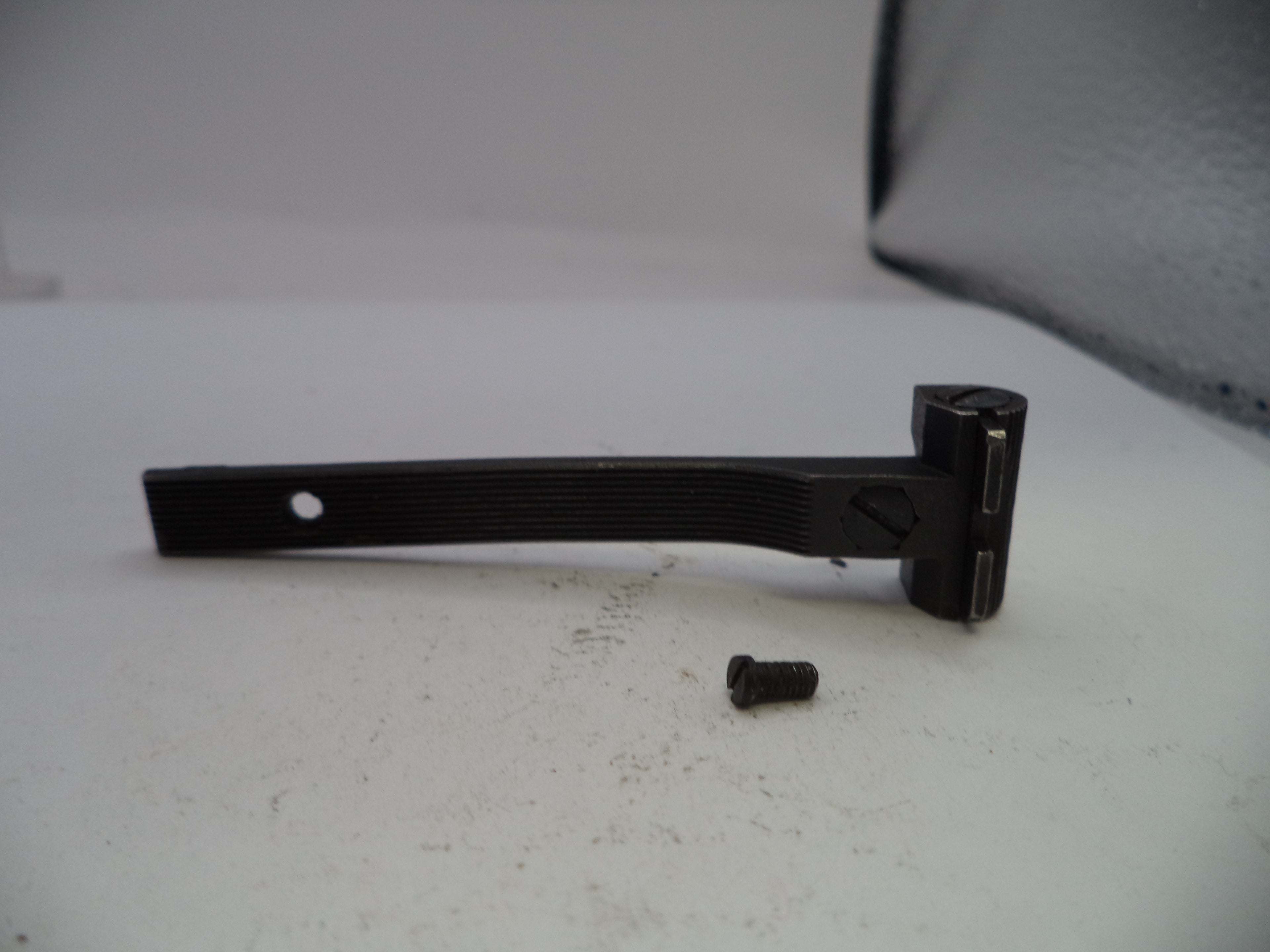 Black metal bracket with a screw on a white surface