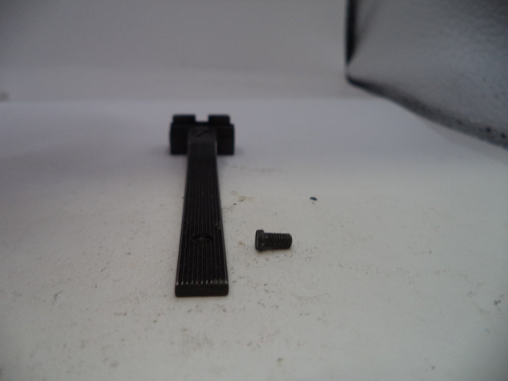 Black metal strip and screw on a white surface