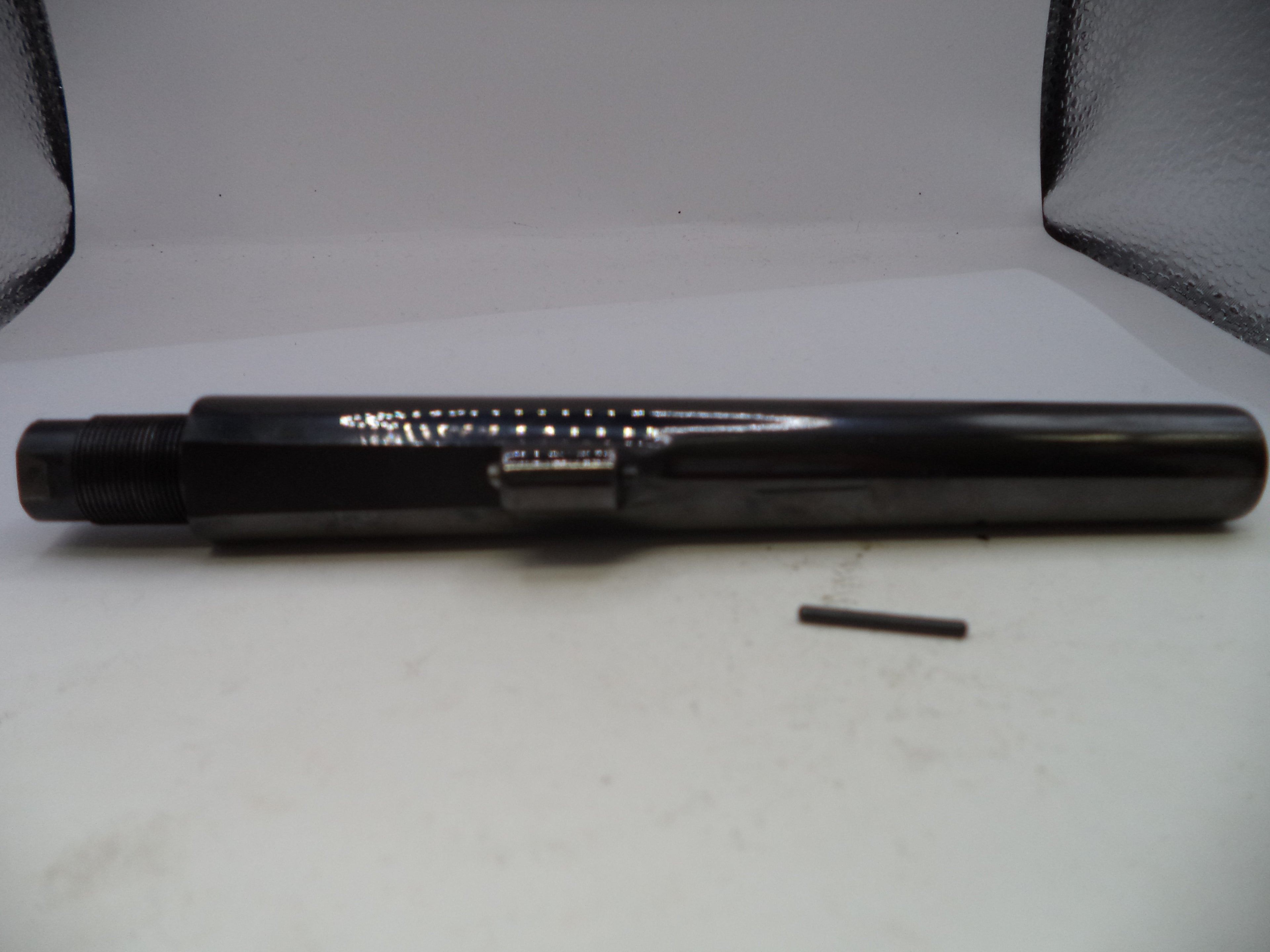 Black cylindrical object with a smaller black object on a white surface