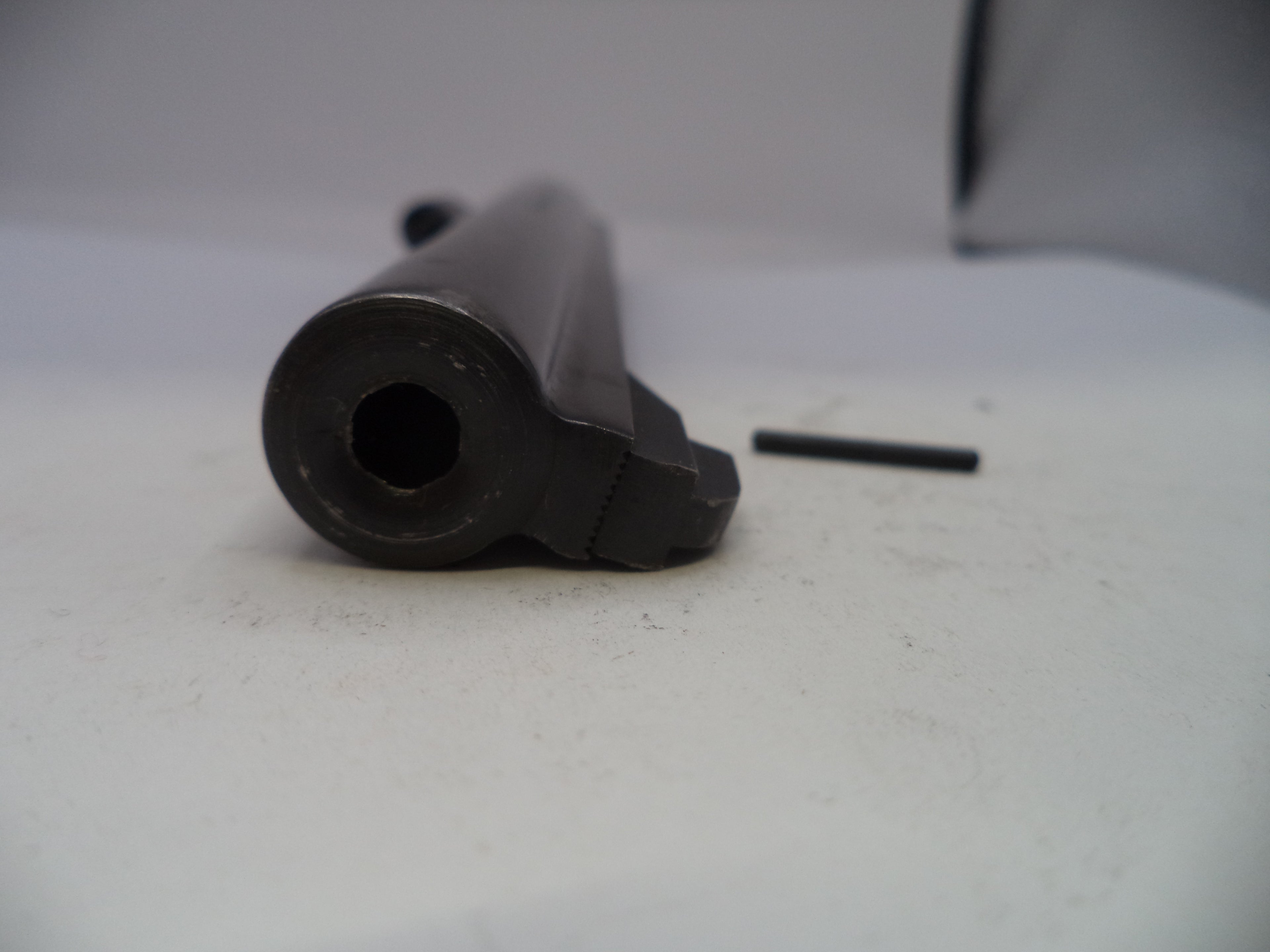 Black cylindrical object on a white surface with a blurred background