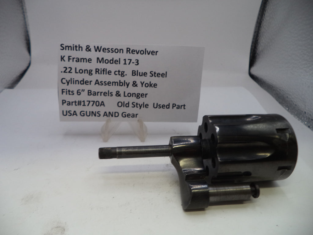 Smith & Wesson revolver cylinder assembly on a white surface with descriptive card.