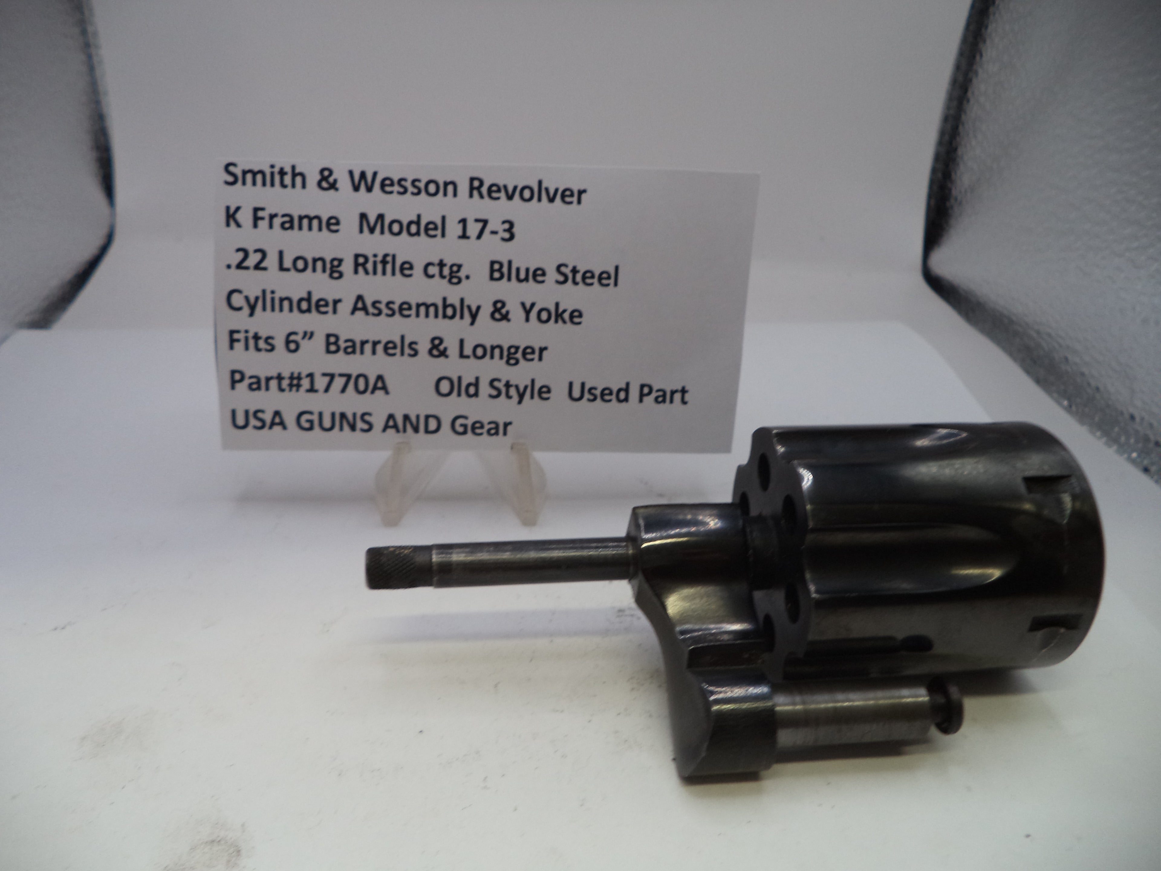 Smith & Wesson revolver cylinder assembly on a white surface with descriptive card.