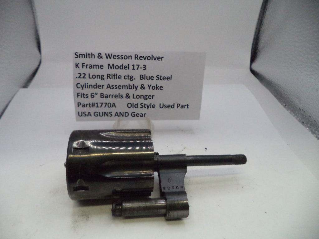 Smith & Wesson revolver cylinder assembly on a white surface with a label.