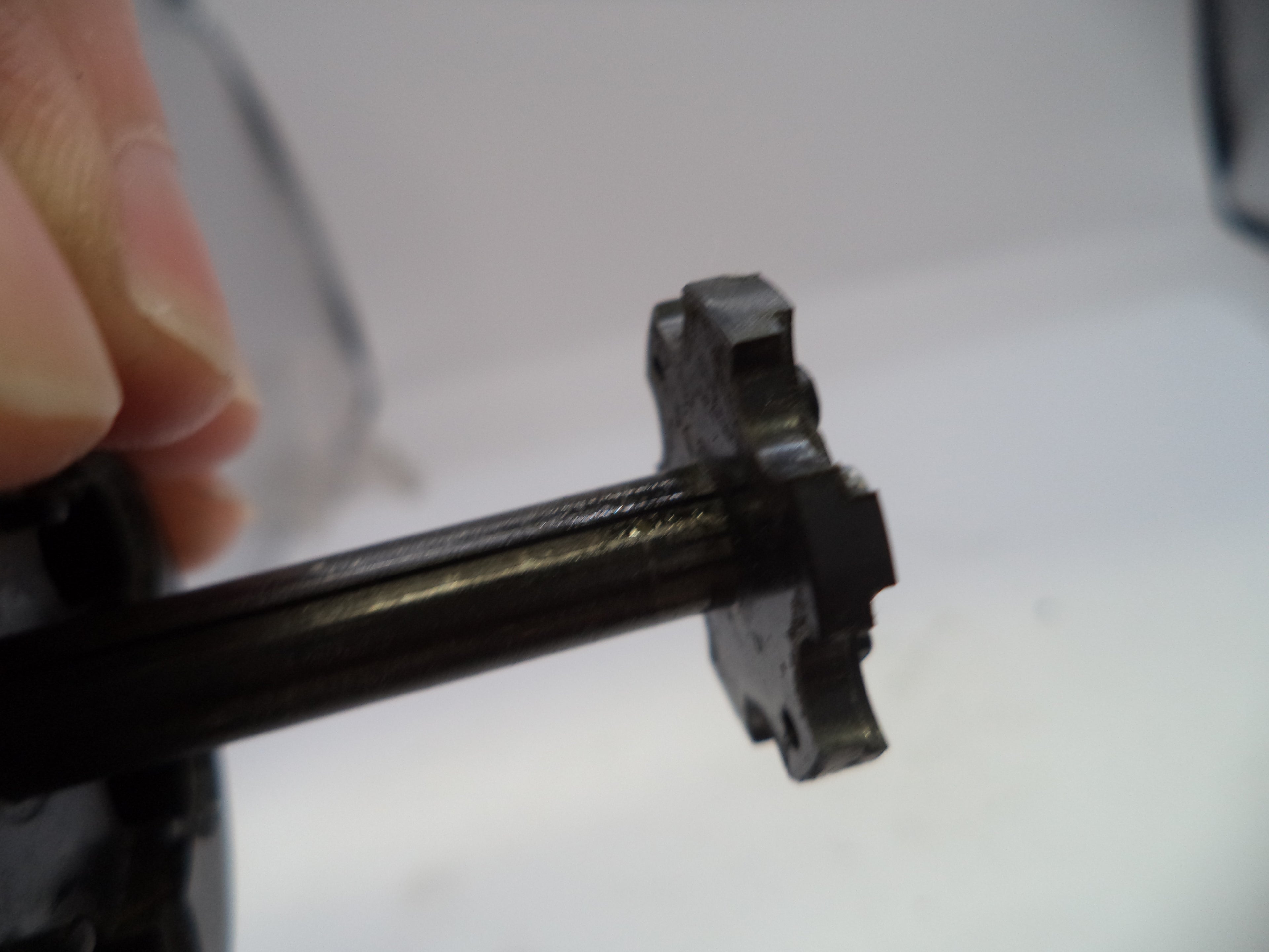 Close-up of a mechanical component held by a hand on a white background