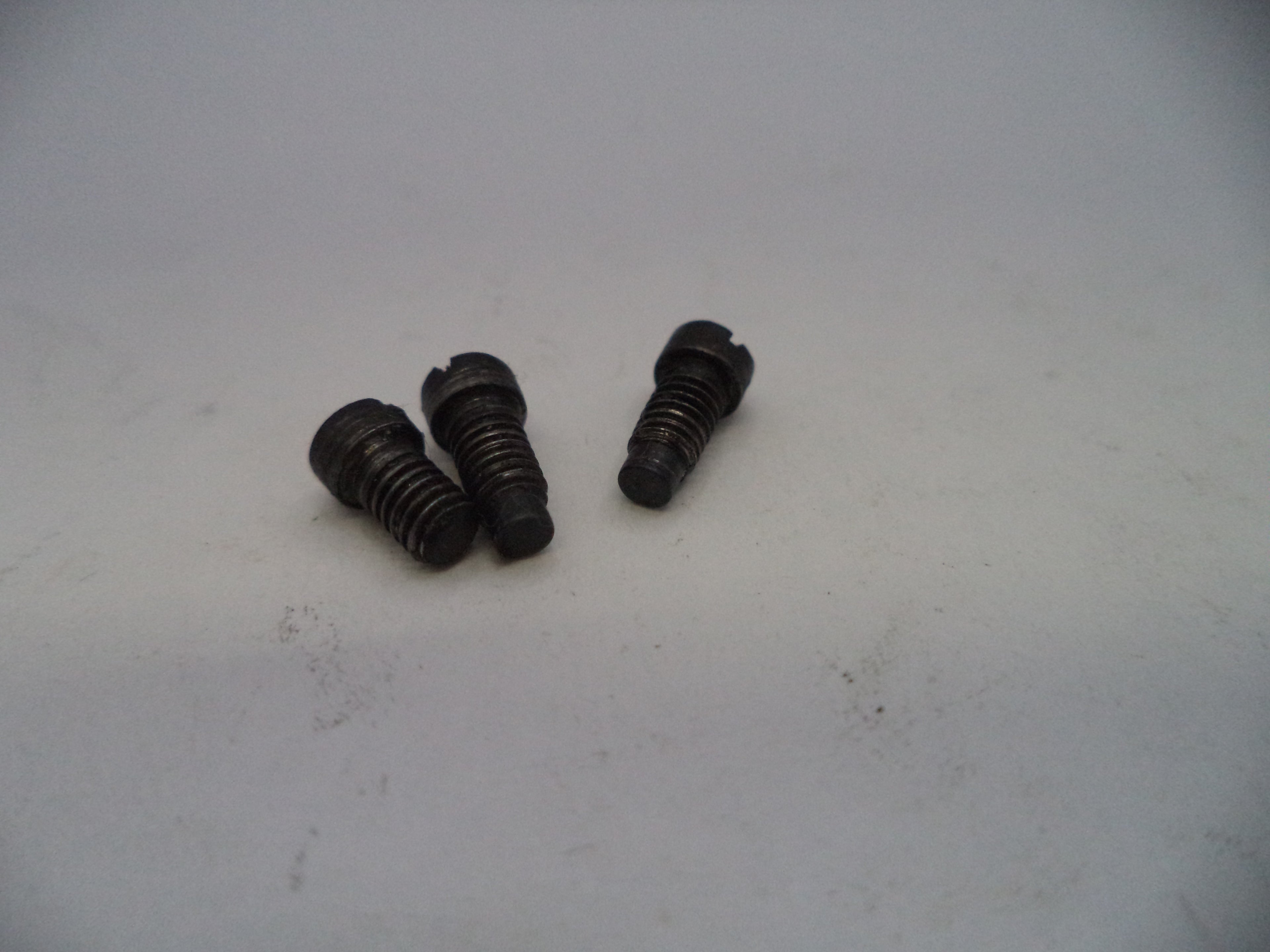 Three black screws on a light gray background