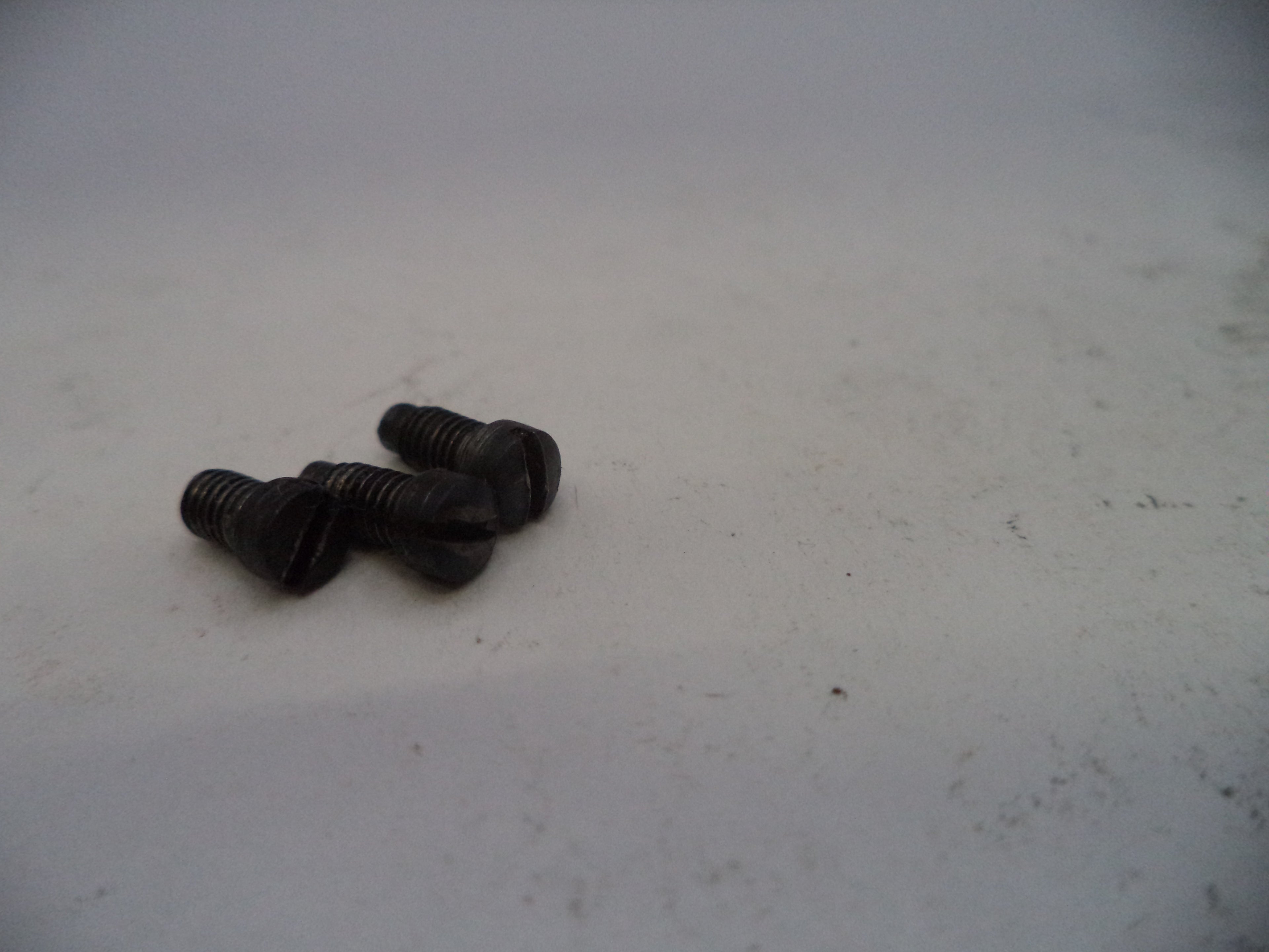 Two black screws on a light gray surface