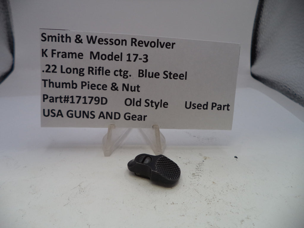 Small black thumb piece and nut with a label on a white surface