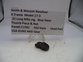 Small black thumb piece and nut with a label on a white surface