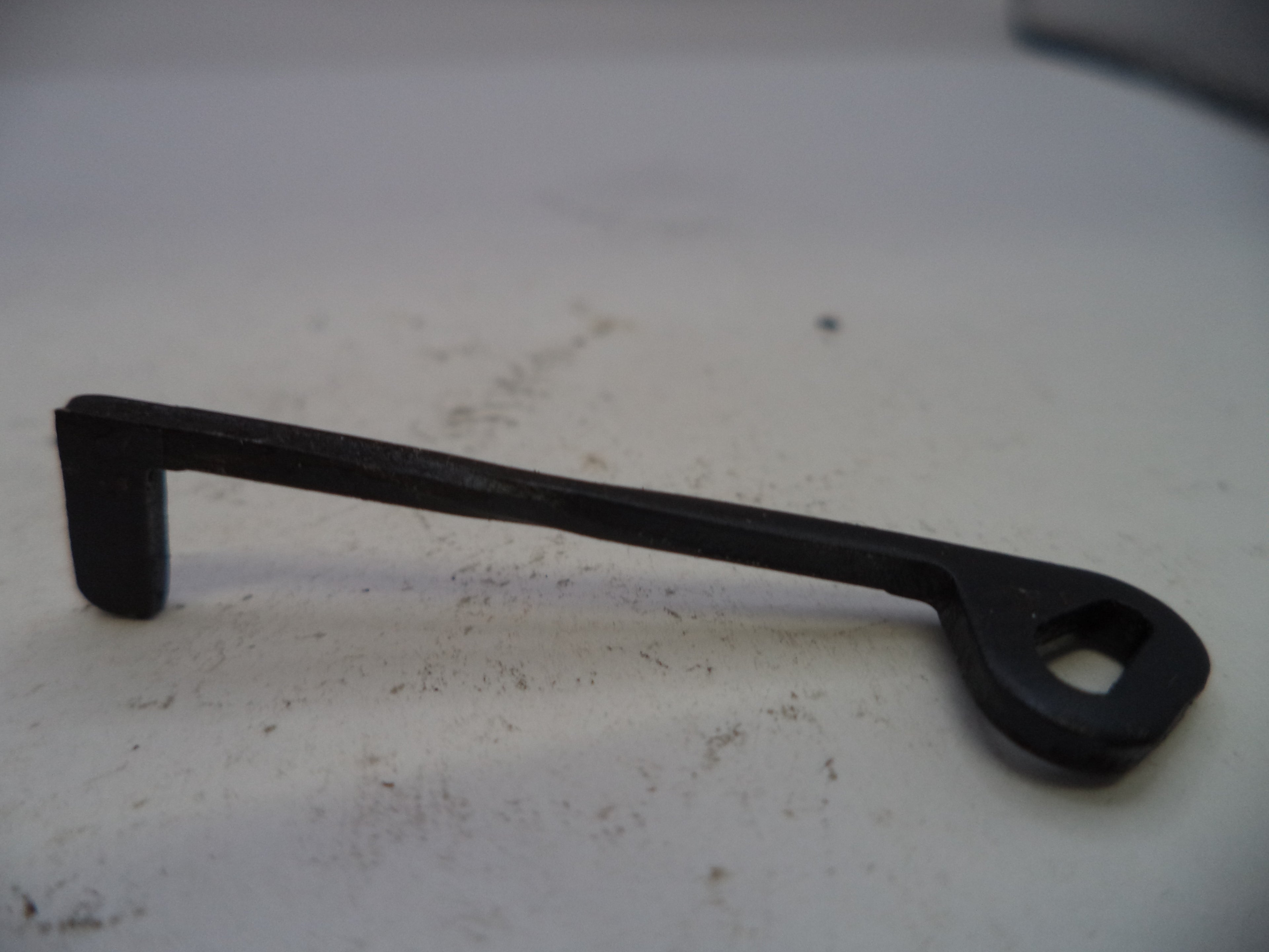 Black metal tool on a white surface