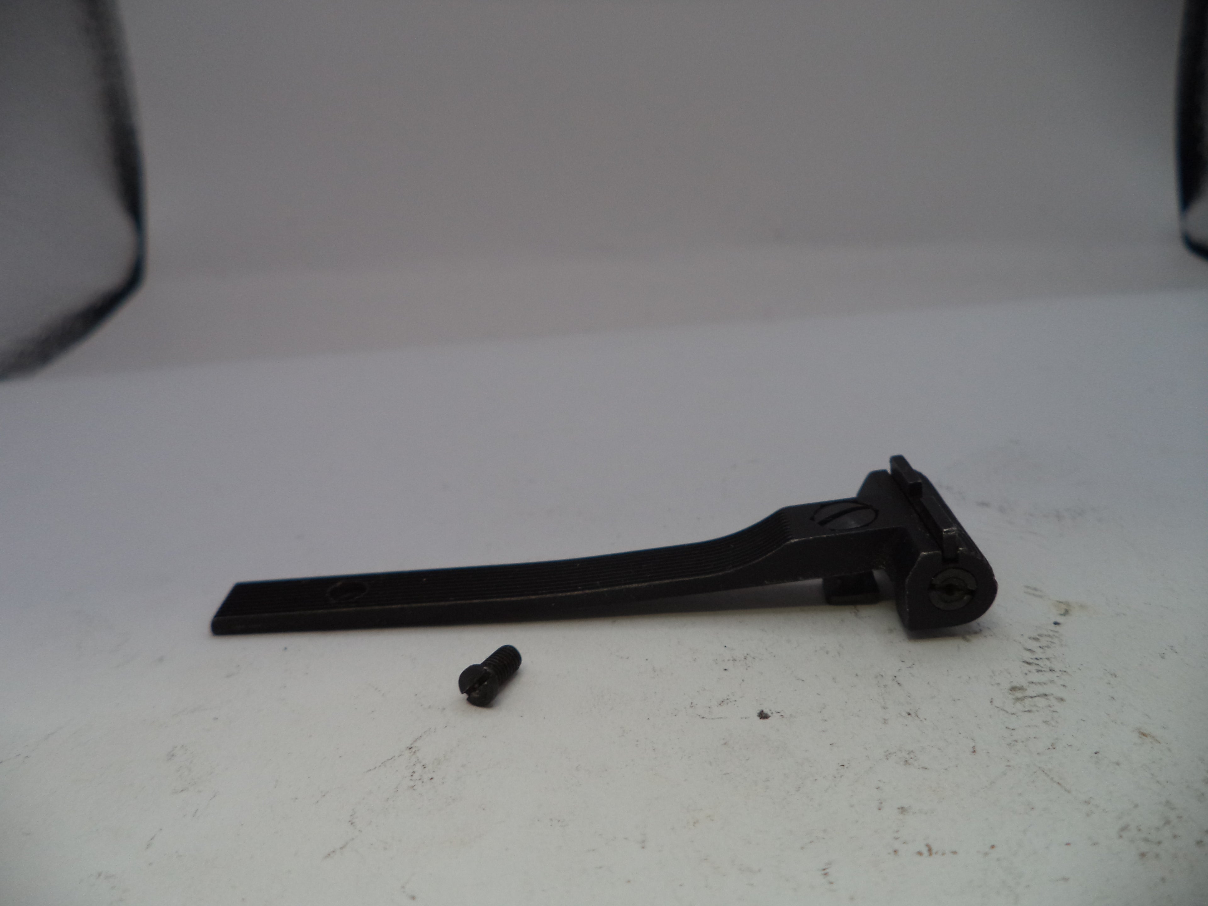 Black metal lever on a white surface with a blurred background