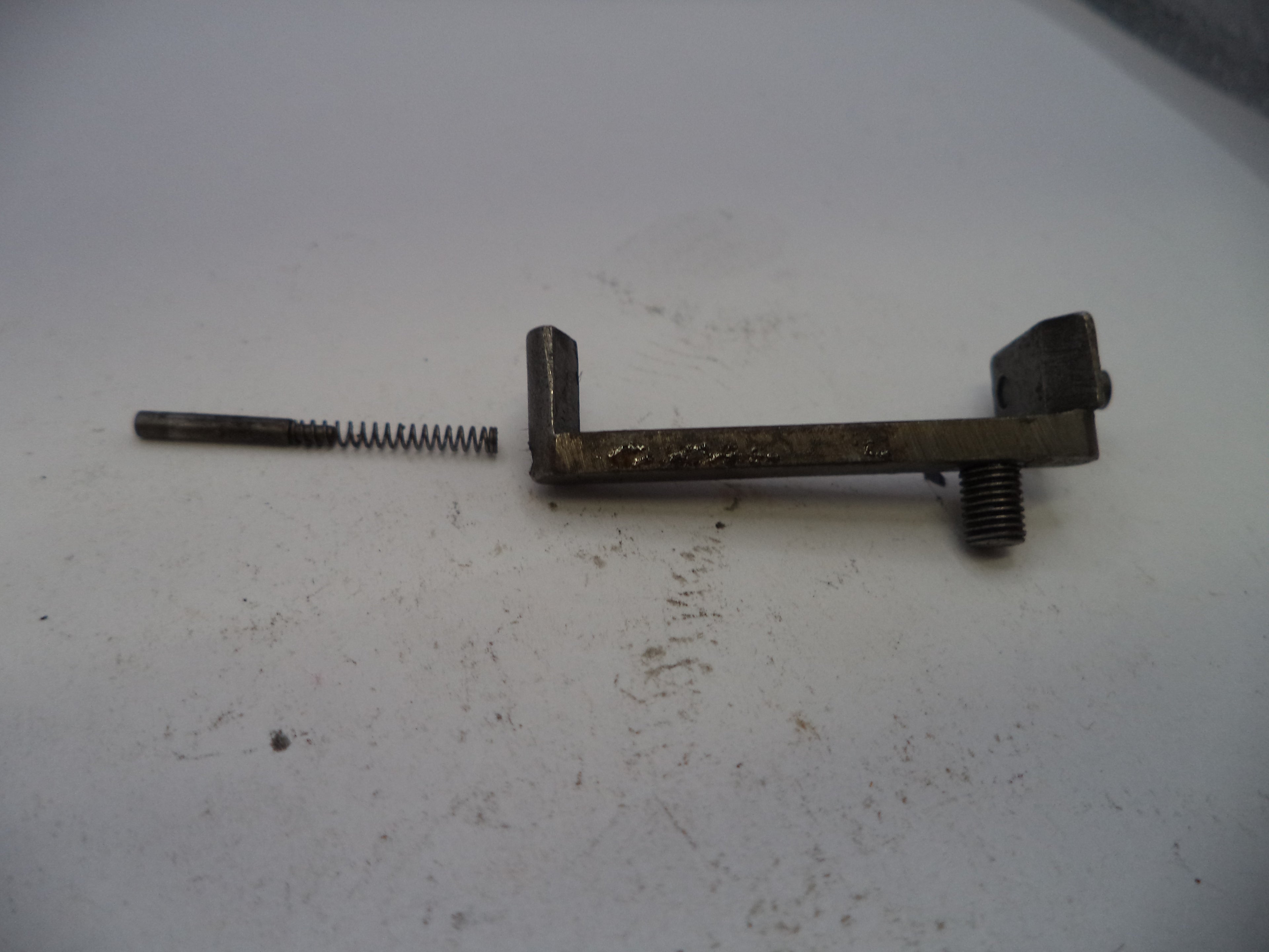 Metal lever with a spring on a white surface