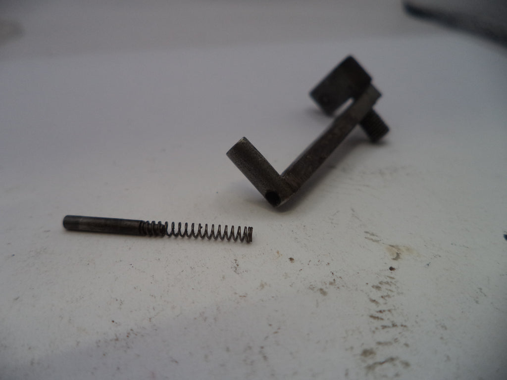 Metal spring and L-shaped bracket on a white surface