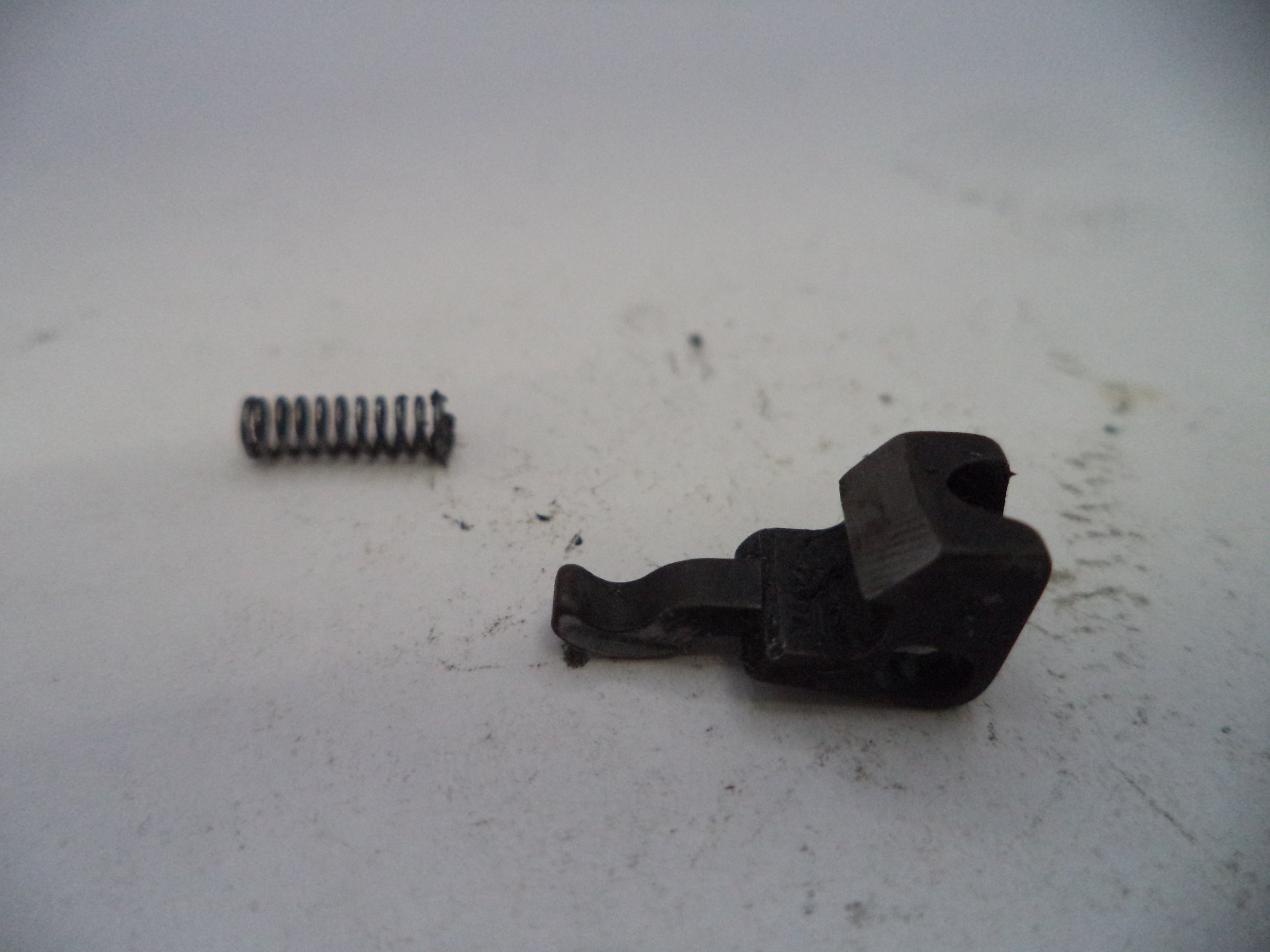 Two black metal components on a white surface