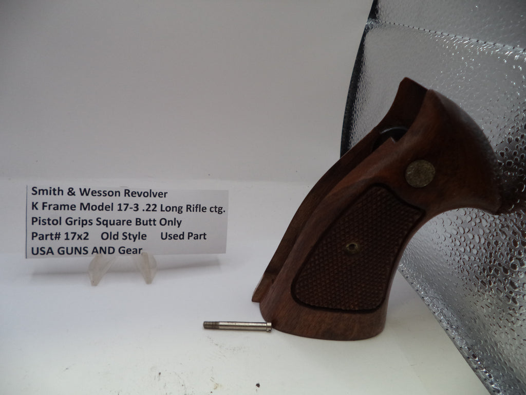 Wooden pistol grip on a white surface with a label in the background.