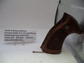 Wooden pistol grip on a white surface with a label in the background.