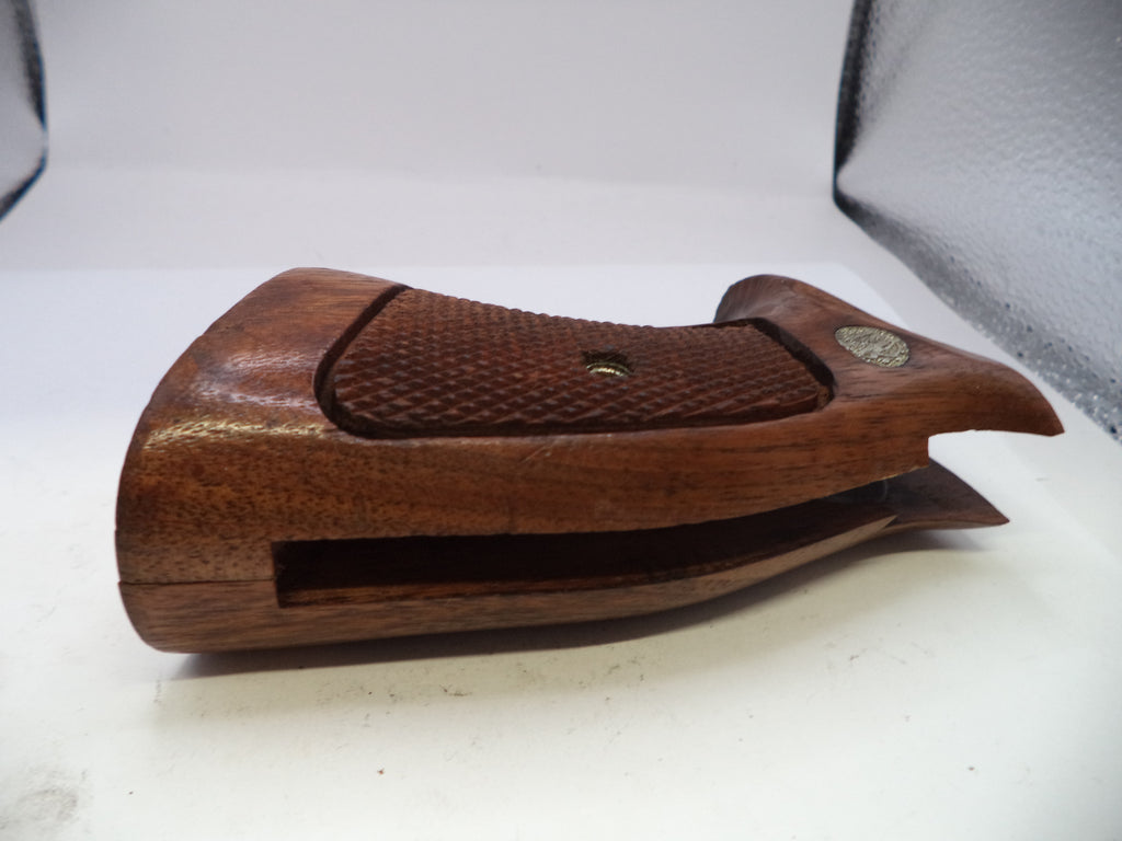 Wooden gun stock on a white surface with a gray background