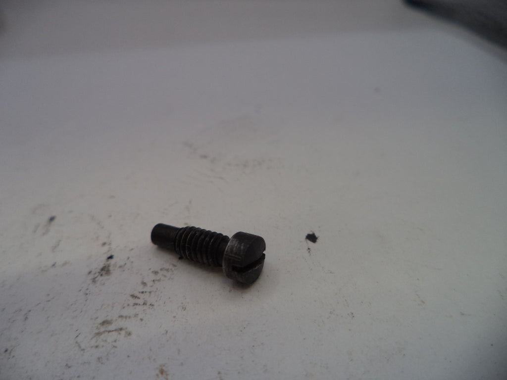 Black screw on a white surface with visible dirt and marks