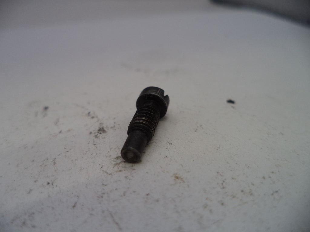 Black screw on a white surface with visible dirt