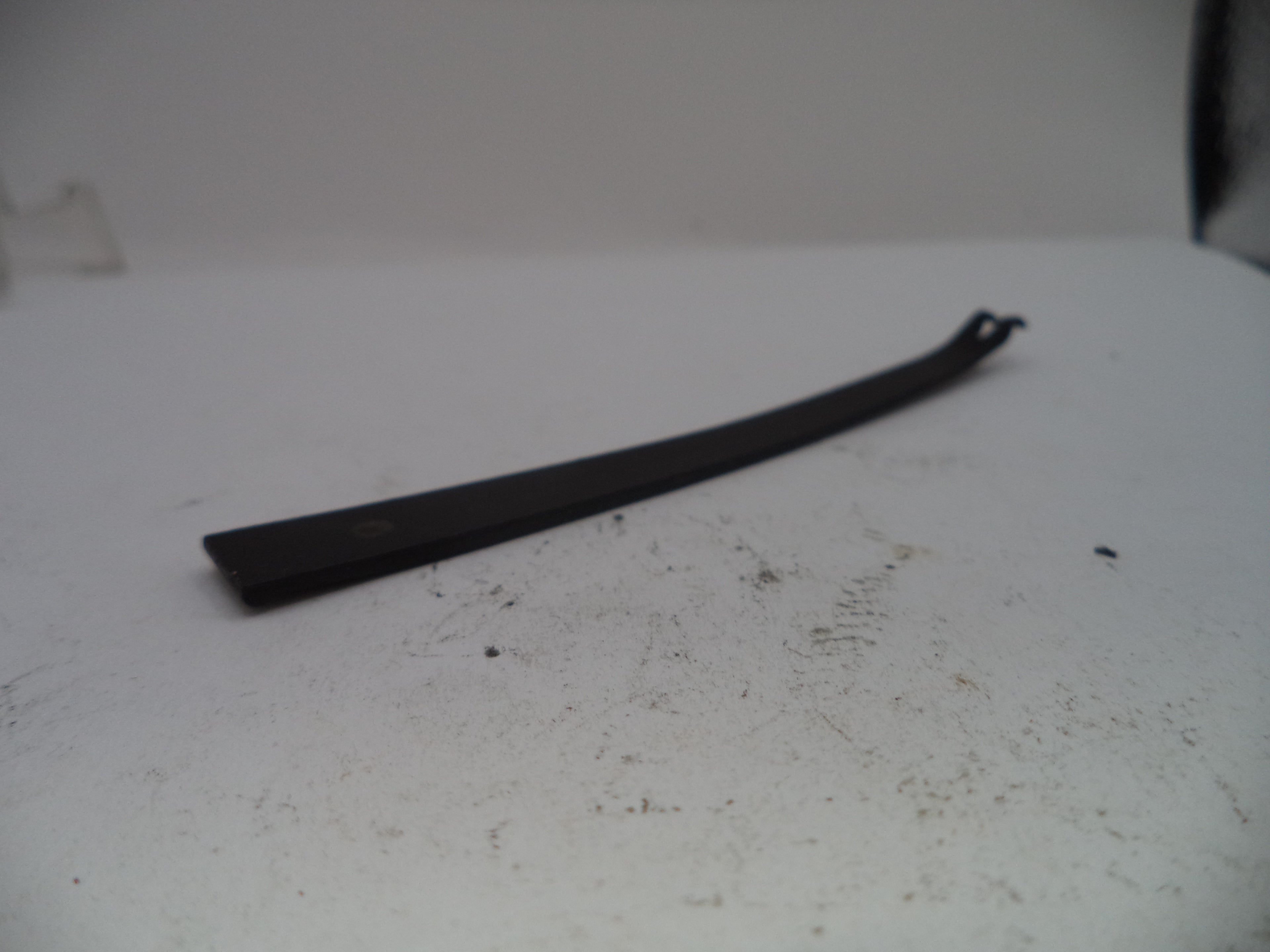 Black metal bar on a white surface with visible dirt