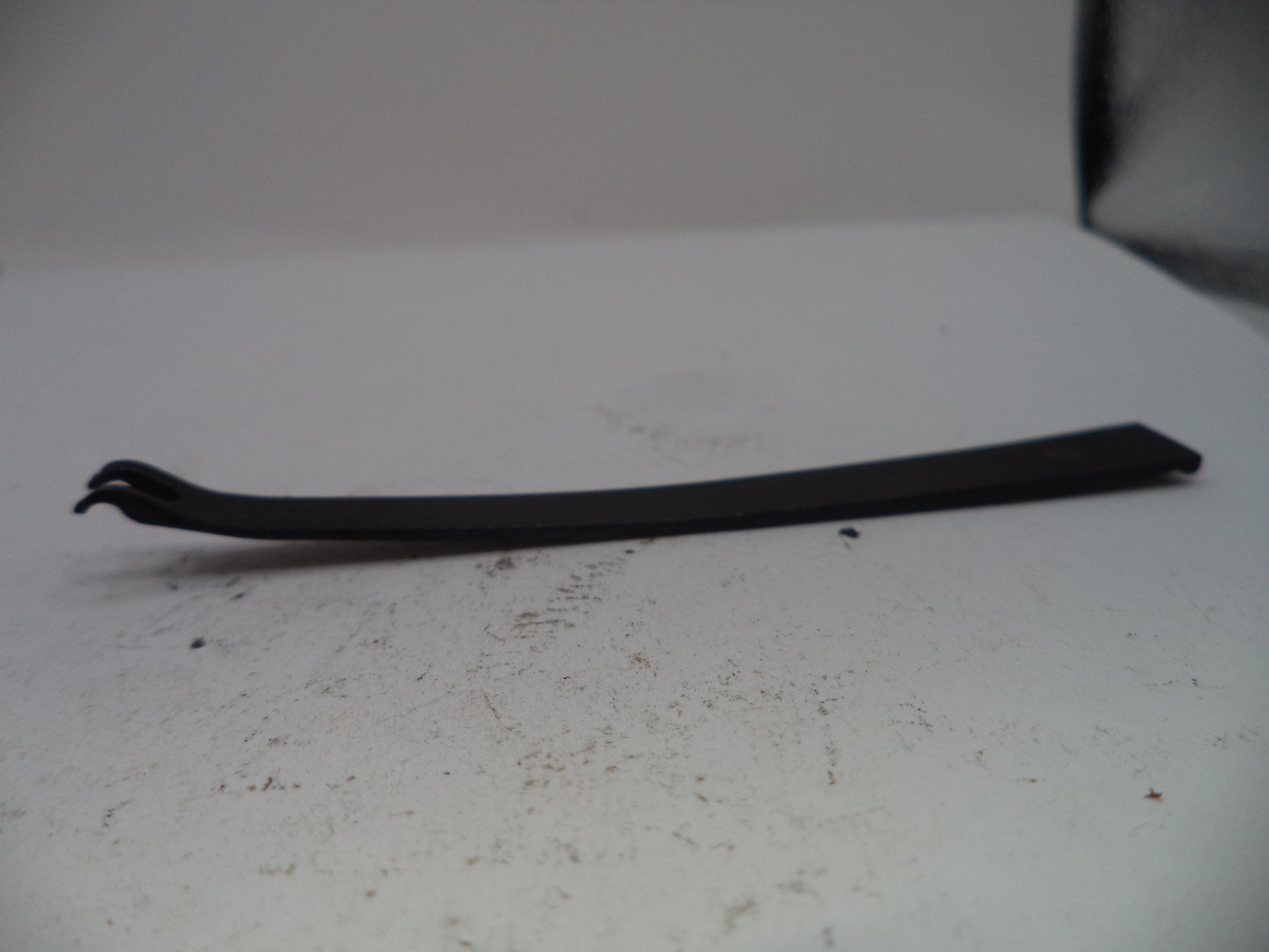 Black metal tool on a white surface with a blurred background