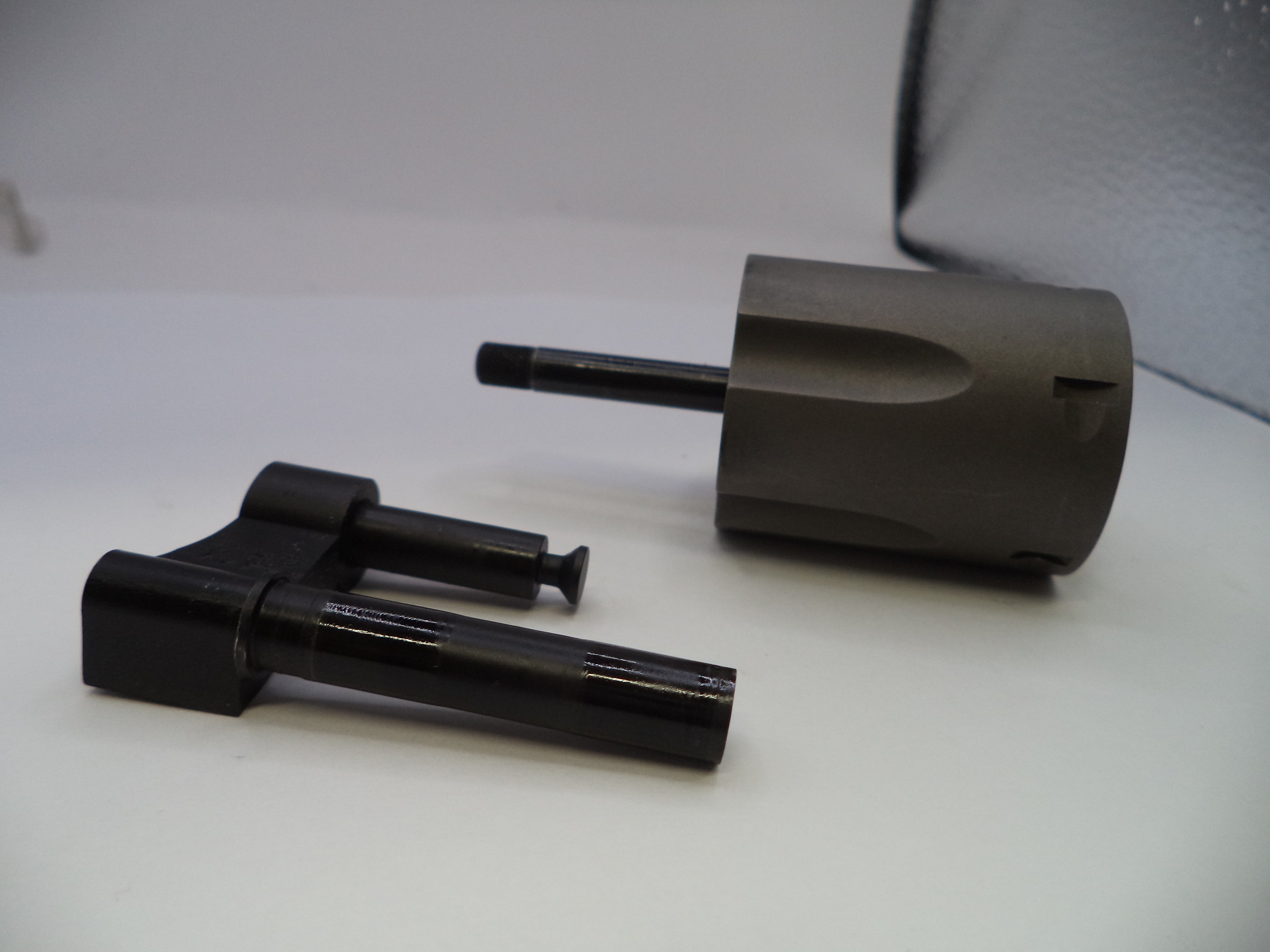Two mechanical components on a white surface with a gray background