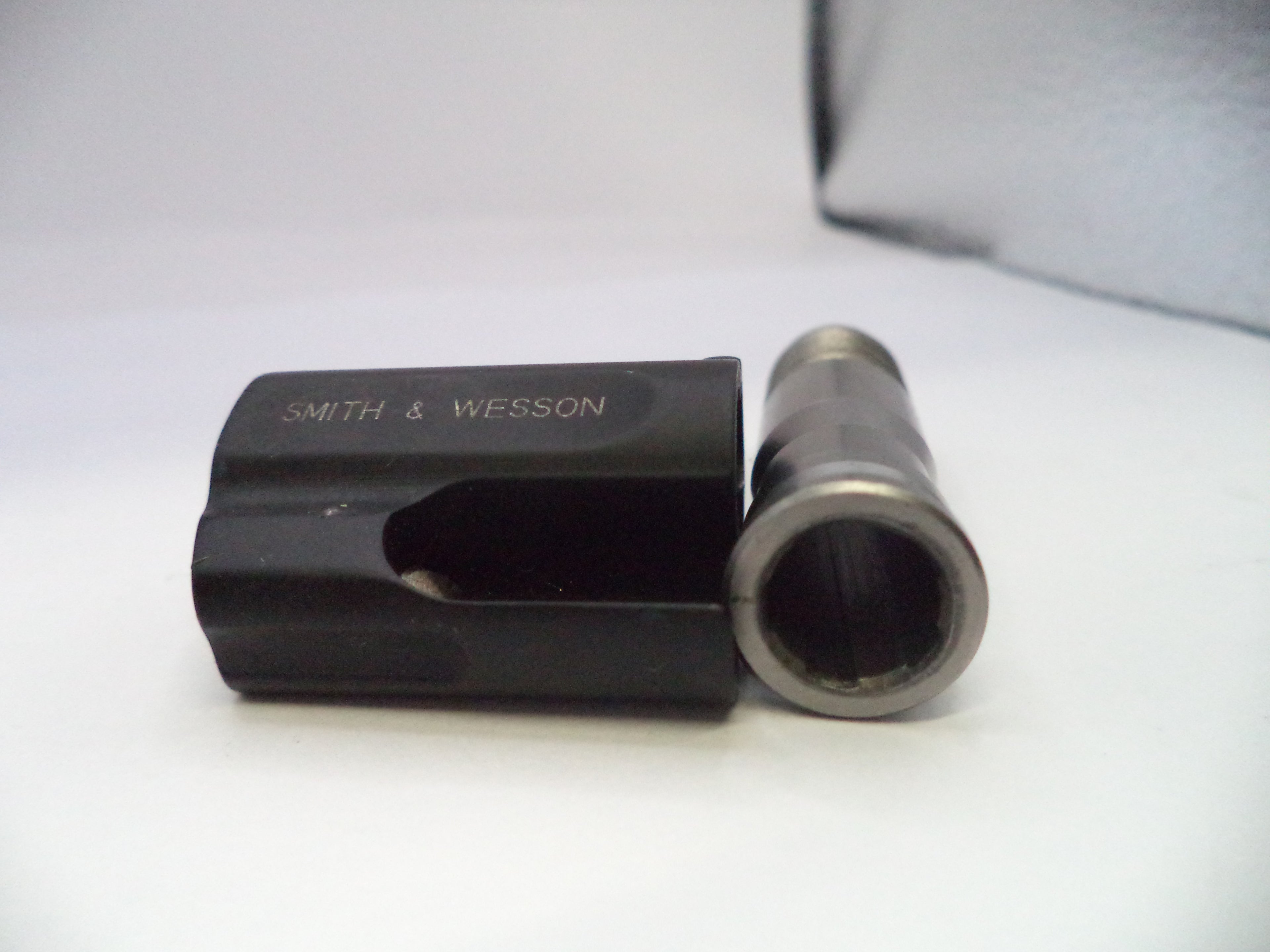 Black and silver cylindrical object with 'Smith & Wesson' branding on a white background