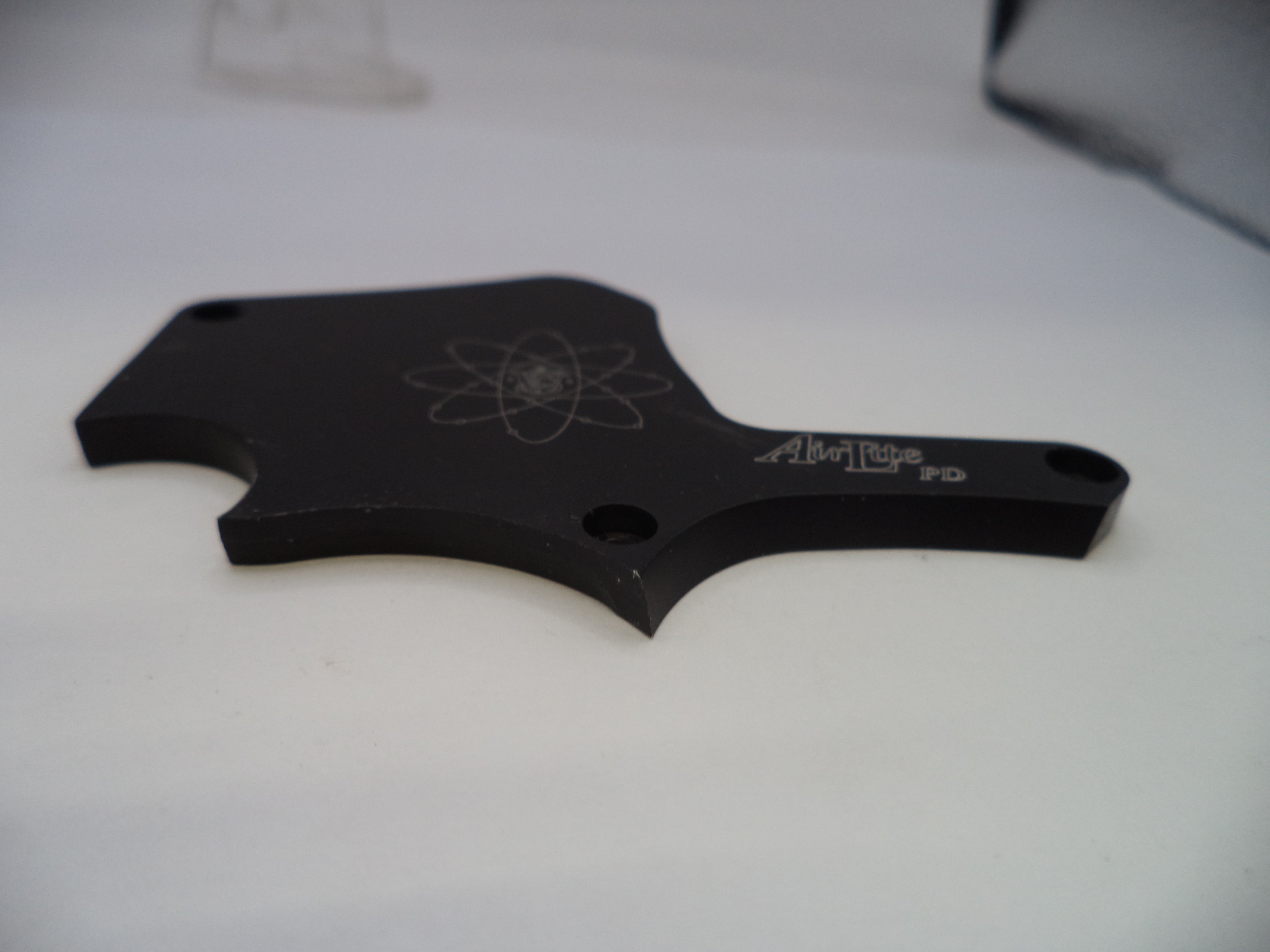 Black metal object with engraved design on a white background