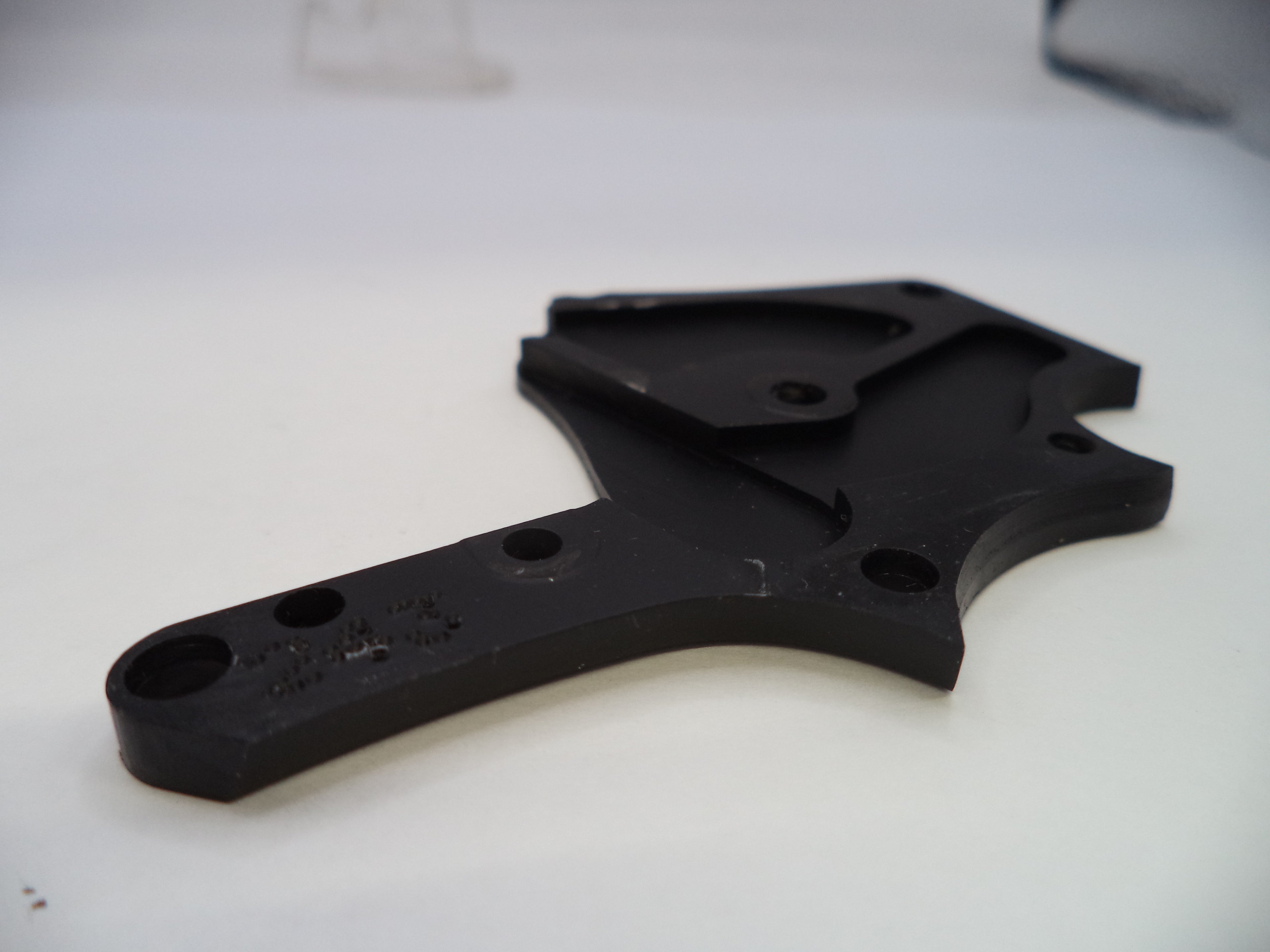 Black plastic component on a white background