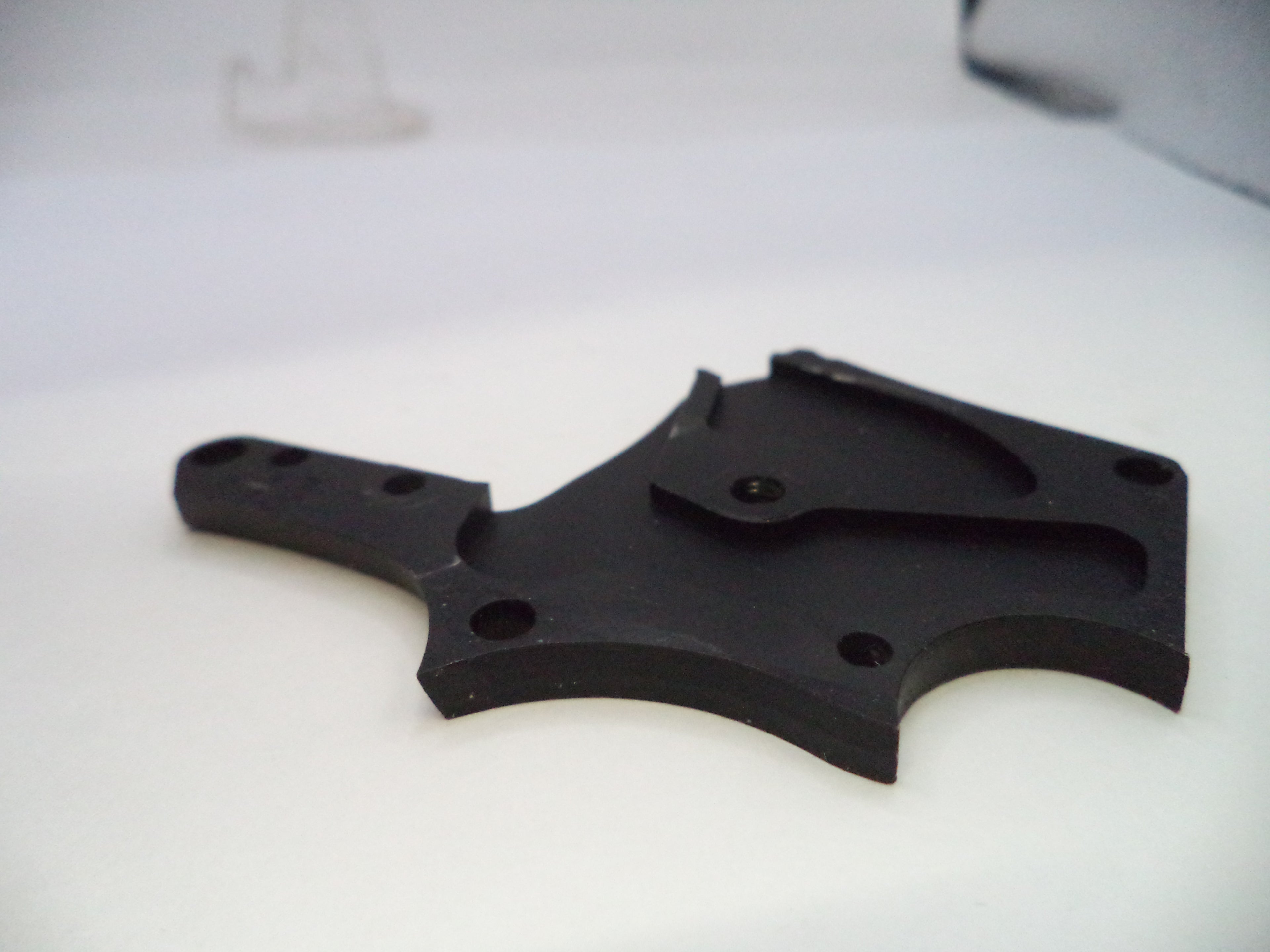 Black plastic component on a white background